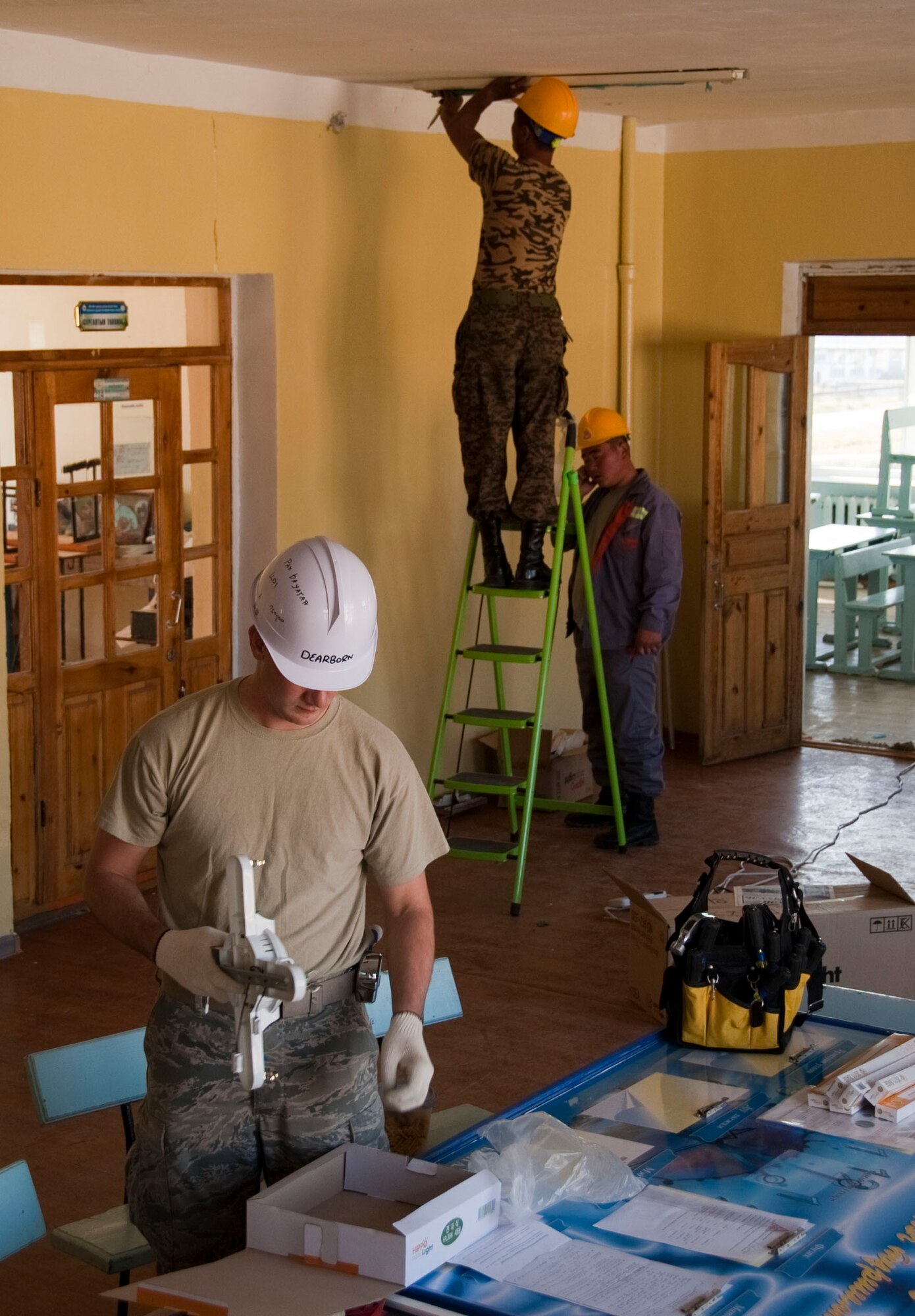 U.S. Air Force Staff Sgt. Christopher Villanueva, a structural engineer and carpenter, works with a Mongolian Armed Forces counterpart to install a mirror in a school in Erdenet, Mongolia, Aug. 11, 2014.  Operation Pacific Angel supports U.S. Pacific Command’s capacity-building efforts by partnering with other governments, non-governmental agencies and multilateral militaries in the respective region to provide medical, dental, optometry and engineering assistance to their citizens. (U.S. Air Force photo by Staff Sgt. William Banton/Released)