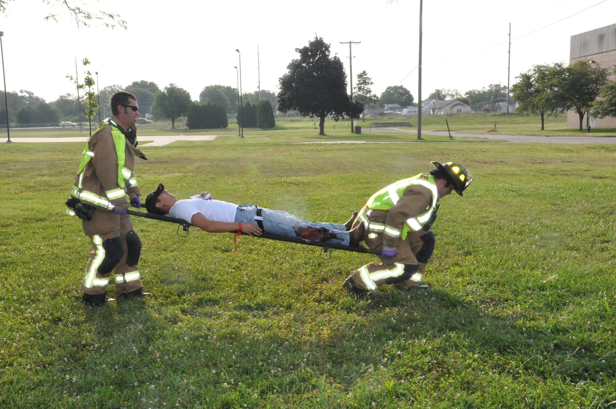Members from the base fire department lift a bus accident victim during a quarterly excercise scenario. (Air Force photo by Diane Kofoed)