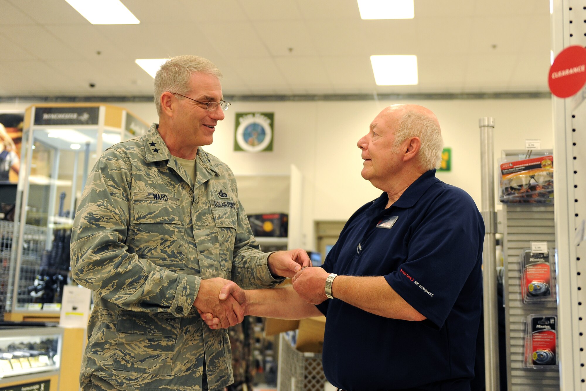 U.S. Air Force Maj. Gen. Joseph S. Ward, Army and Air Force Exchange Services deputy director, gives a coin to Base Exchange employee Mike Kegley, a firearm expert in the Outdoor Living section, as part of his tour Aug. 14 at Offutt Air Force Base, Nebraska. Kegley has been with the BX since its grand opening in June 2008.  (U.S. Air Force photo by Josh Plueger/Released)