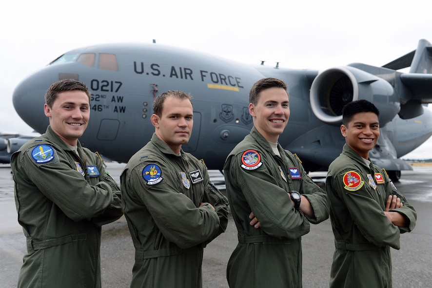 1st Lt. Craig Duffy(from left to right), 7th Airlift Squadron pilot, 1st Lt. Darren Stowe, 8th AS pilot, Staff Sgt. David Schmitz, 4th AS instructor loadmaster, and Senior Airman Ben Gatdula, 10th AS loadmaster, show their squadron patches in front of a C-17 Globemaster III Aug. 13, 2014, at Joint Base Lewis-McChord, Wash. In transition to a new deployment schedule, all four of the 62nd Airlift Wing’s airlift squadrons are home.(U.S. Air Force photo/Airman 1st Class Jacob Jimenez)