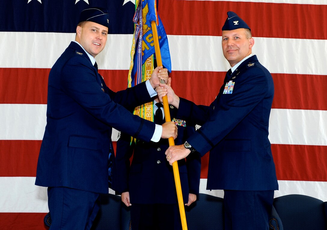 Col. John Nichols, 14th Flying Training Wing Commander, passes the 14th Mission Support Group guidon to Col. Kurt Kayser, during a change of command ceremony Aug. 12 at the Fire Station.(U.S. Air Force photo/ Elizabeth Owens)
