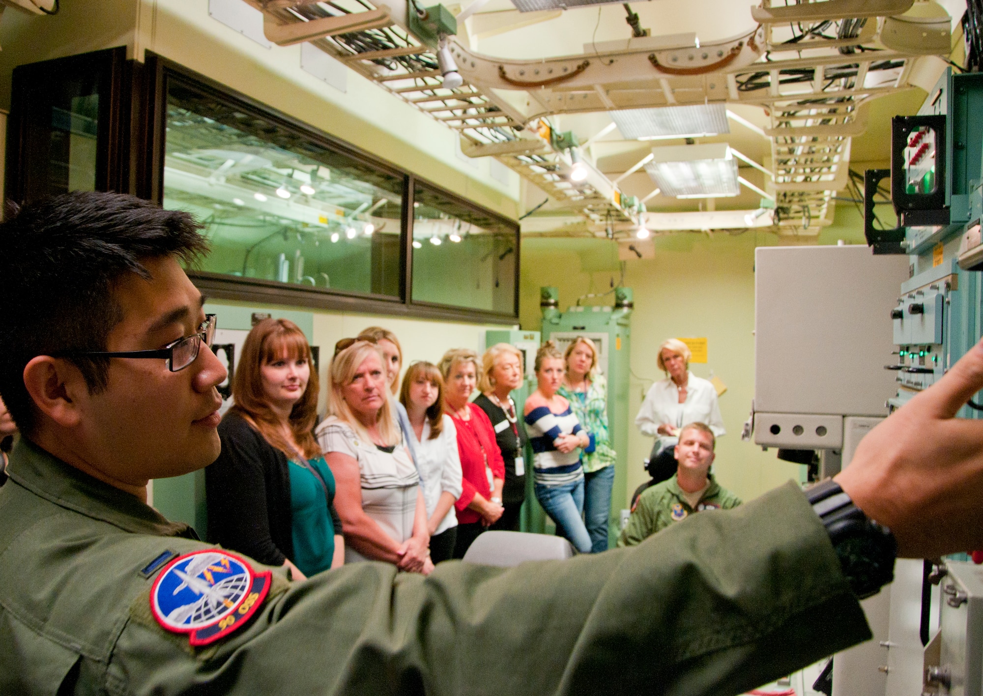 First Lt. Daniel Choi, 90th Operations Support Squadron deputy missile combat crew instructor, describes how the Minuteman III ICBM launch control centers communicate with each other and higher levels of command to a delegation of staff members from the offices of the U.S. Congressmen from Wyoming Aug. 13, 2014, in the 90th Operations Group Missile Procedures Trainer. The staff’s tour consisted of a trip to the 90th Missile Wing Headquarters, the MPT, and the U-01 and U-02 training sites. (U.S. Air Force photo by Airman 1st Class Jason Wiese)