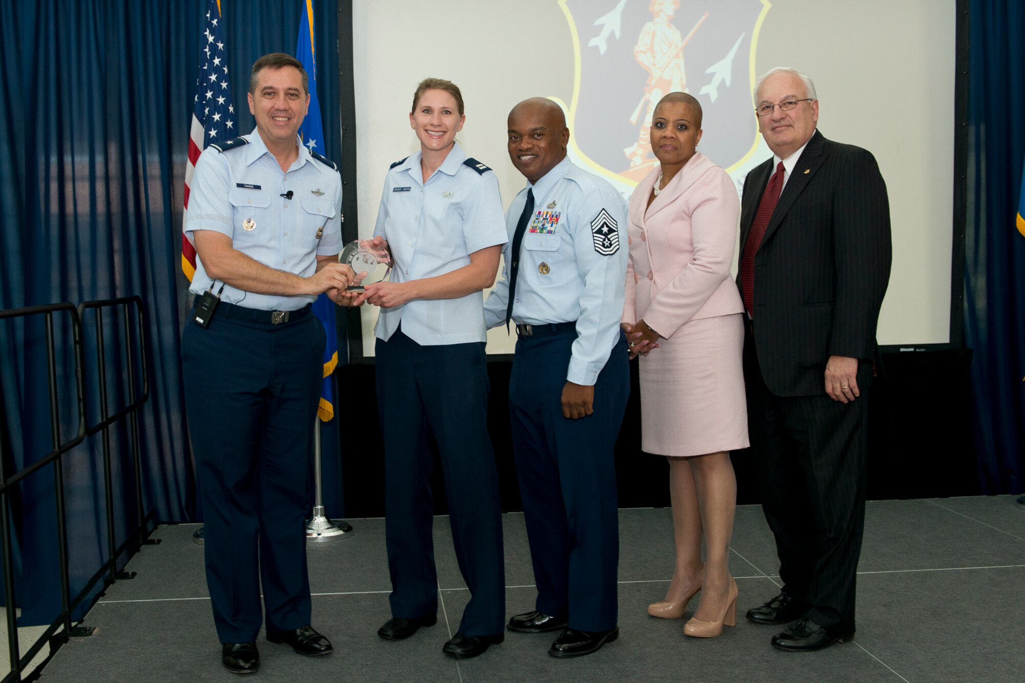 Brig. Gen. Michael R. Taheri, commander of the Air National Guard Readiness Center and Chief Master Sgt. Tony L. Whitehead, command chief master sergeant of the ANGRC, present the Company Grade Officer of the Quarter award to Capt. Jessica R. Gruver Koefod during the 2nd Quarter Awards Ceremony and Commander’s Call August 14, 2014. Rosalind Bishop, Joint Base Andrews branch manager of Andrews Federal Credit Union and Paul Ariente, president of the National Guard Bureau Alumni Association were sponsors for the event. (Air National Guard photo by Master Sgt. Marvin R. Preston/Released)