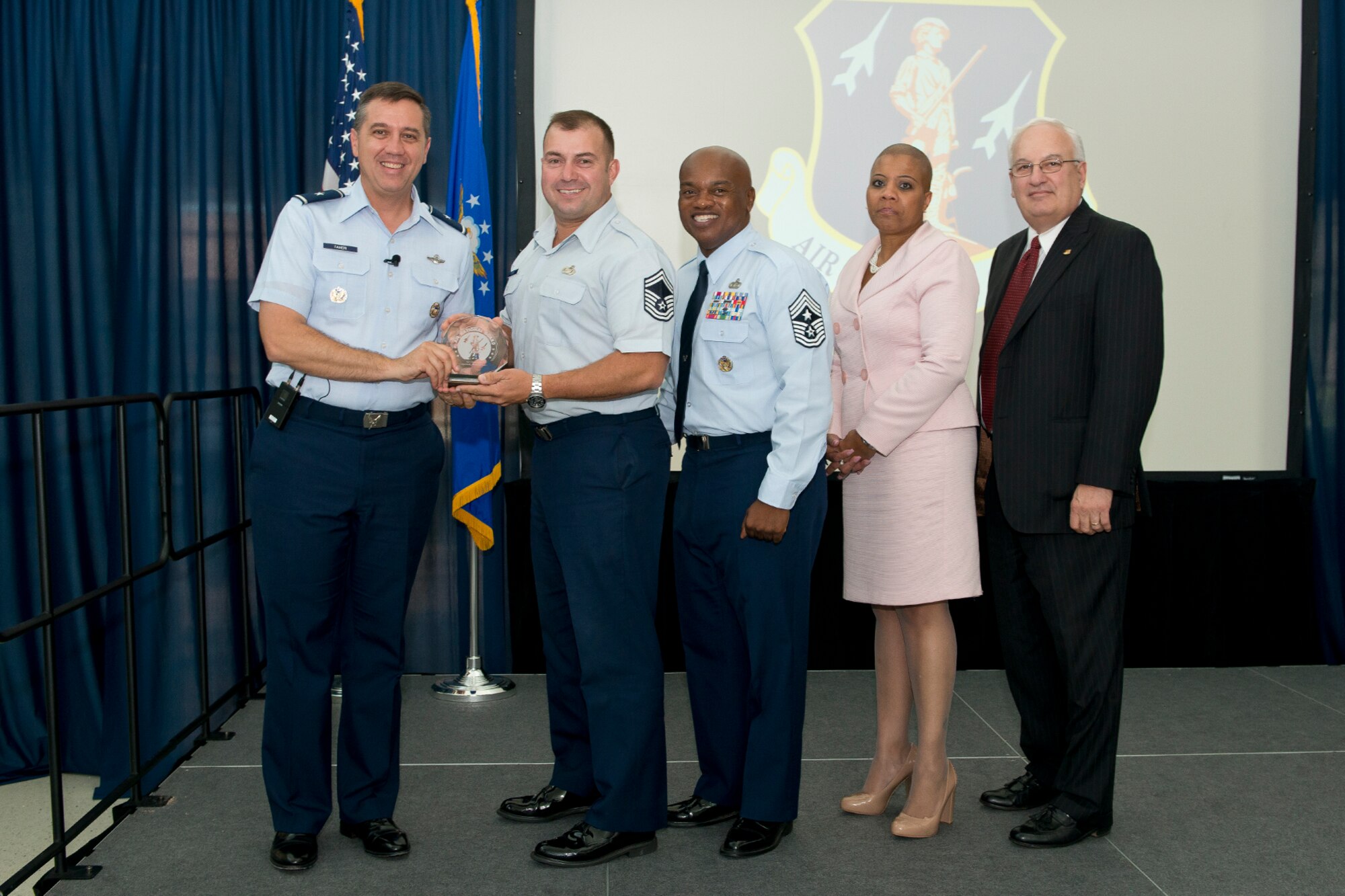 Brig. Gen. Michael R. Taheri, commander of the Air National Guard Readiness Center and Chief Master Sgt. Tony L. Whitehead, command chief master sergeant of the ANGRC, present the Senior Non-Commissioned Officer of the Quarter award to Senior Master Sgt. Angel L. Luna during the 2nd Quarter Awards Ceremony and Commander’s Call August 14, 2014. Rosalind Bishop, Joint Base Andrews branch manager of Andrews Federal Credit Union and Paul Ariente, president of the National Guard Bureau Alumni Association were sponsors for the event. (Air National Guard photo by Master Sgt. Marvin R. Preston/Released)