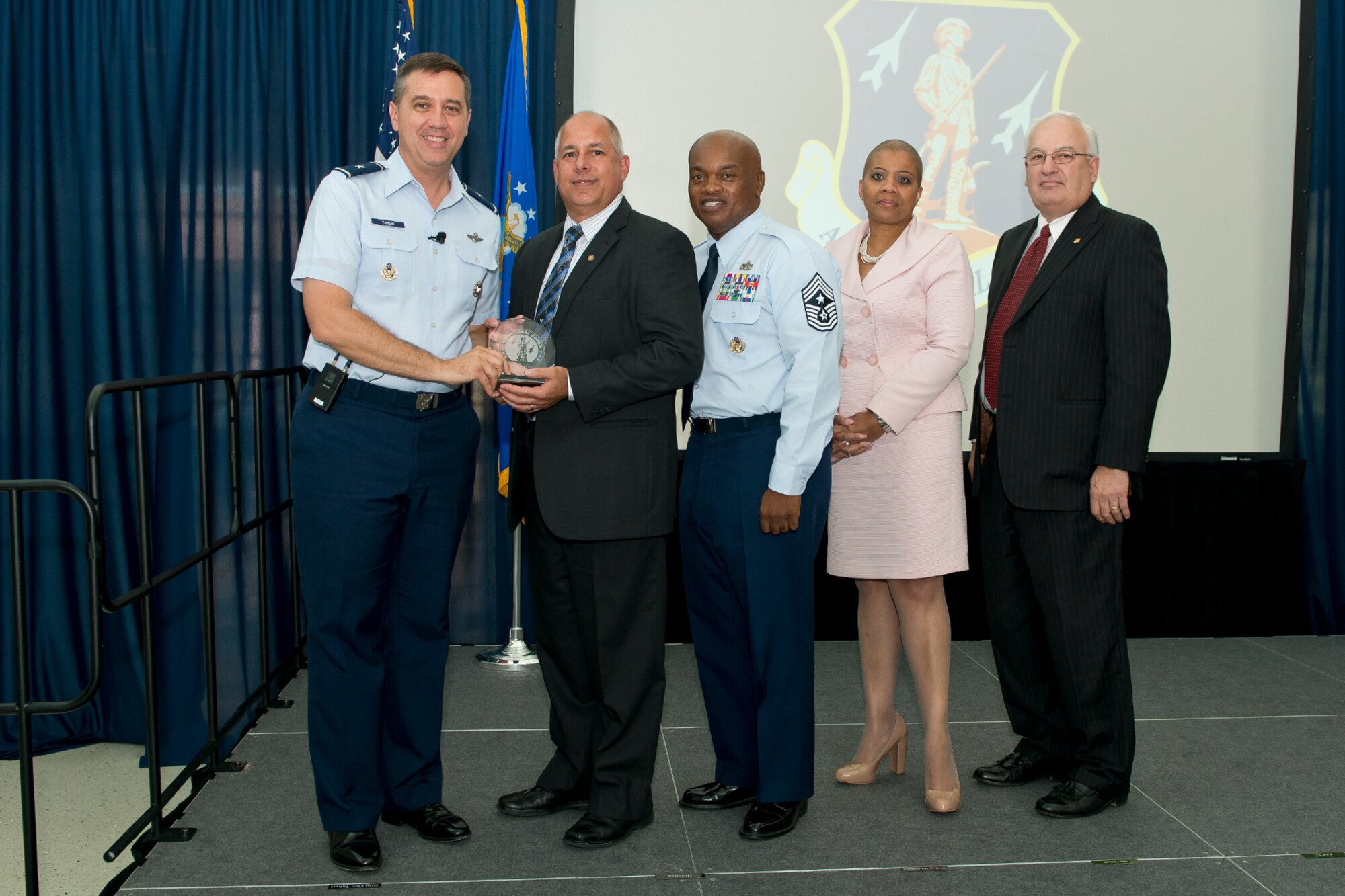 Brig. Gen. Michael R. Taheri, commander of the Air National Guard Readiness Center and Chief Master Sgt. Tony L. Whitehead, command chief master sergeant of the ANGRC, present the Civilian of the Quarter, Category 3 award to James A. Guevara during the 2nd Quarter Awards Ceremony and Commander’s Call August 14, 2014. Rosalind Bishop, Joint Base Andrews branch manager of Andrews Federal Credit Union and Paul Ariente, president of the National Guard Bureau Alumni Association were sponsors for the event. (Air National Guard photo by Master Sgt. Marvin R. Preston/Released)