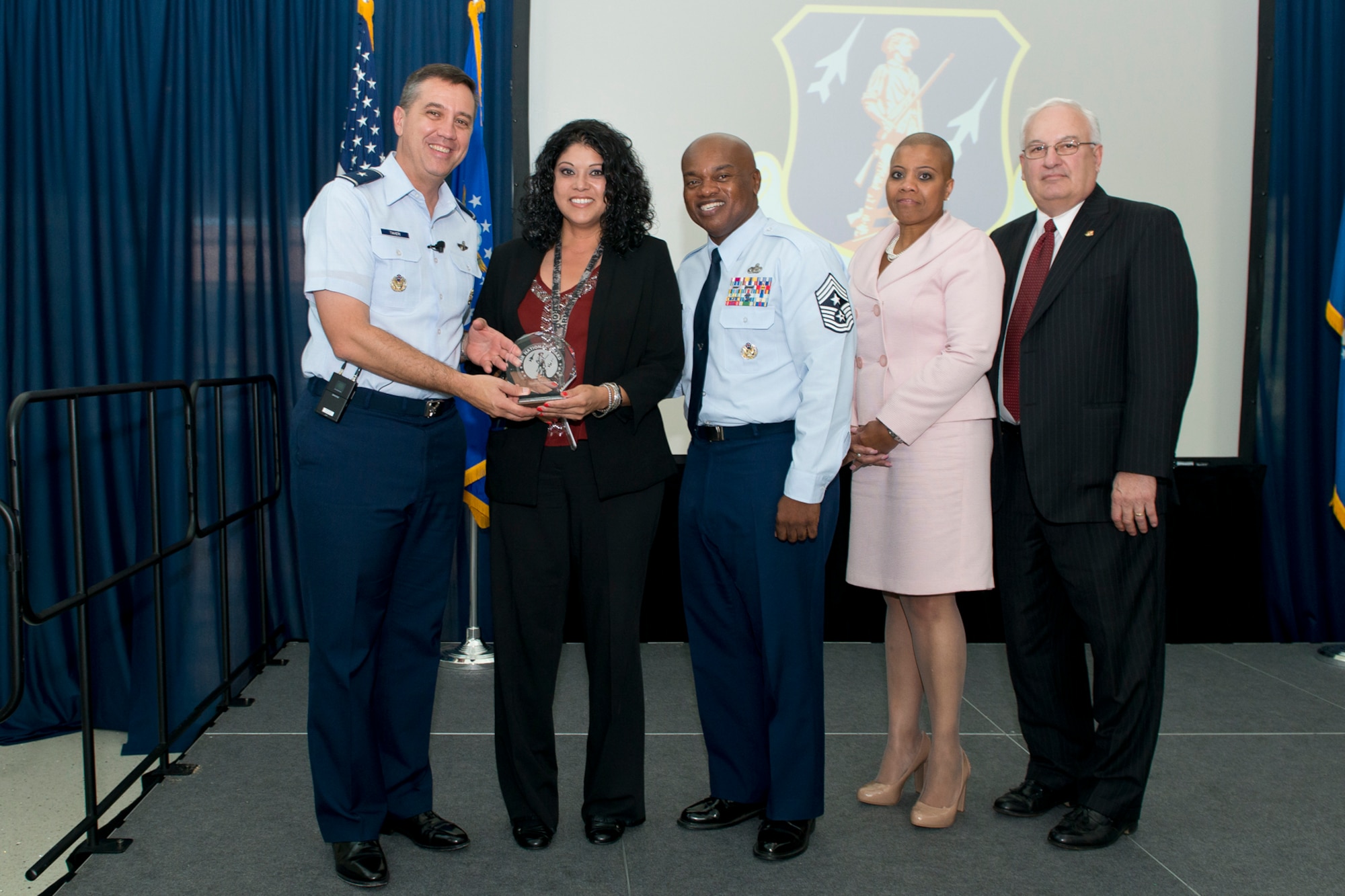 Brig. Gen. Michael R. Taheri, commander of the Air National Guard Readiness Center and Chief Master Sgt. Tony L. Whitehead, command chief master sergeant of the ANGRC, present the Civilian of the Quarter, Category I award to Gloria Fernandez during the 2nd Quarter Awards Ceremony and Commander’s Call August 14, 2014. Rosalind Bishop, Joint Base Andrews branch manager of Andrews Federal Credit Union and Paul Ariente, president of the National Guard Bureau Alumni Association were sponsors for the event. (Air National Guard photo by Master Sgt. Marvin R. Preston/Released)