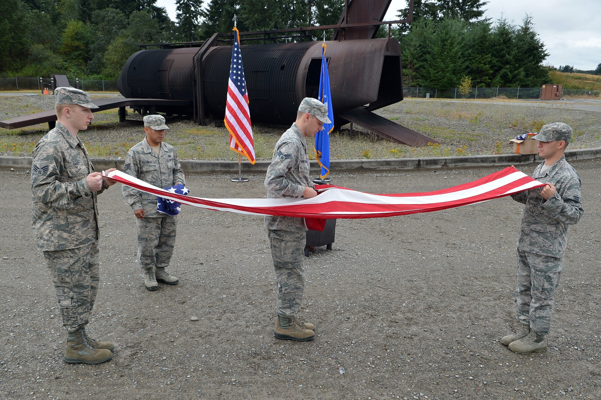 McChord Field honor guard members cut a flag to prepare it for burning during a flag retirement ceremony Aug. 13, 2014, at Joint Base Lewis-McChord, Wash. This is the first time the McChord Field Honor Guard has performed a flag retirement ceremony. (U.S. Air Force photo/Airman 1st Class Keoni Chavarria)  