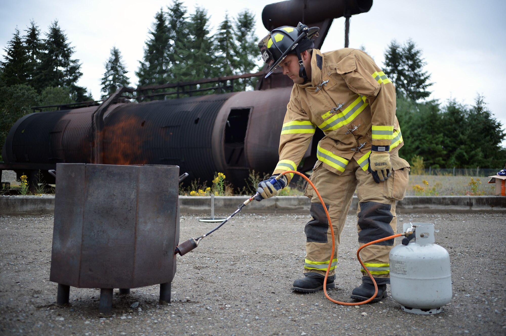 Josh Olsen, Directorate of Emergency Services firefighter, lights a fire for a flag retirement ceremony, Aug. 13, 2014, at Joint Base Lewis-McChord, Wash. The ceremony took place at the fire department training grounds on McChord Field. (U.S. Air Force photo/Airman 1st Class Keoni Chavarria)  