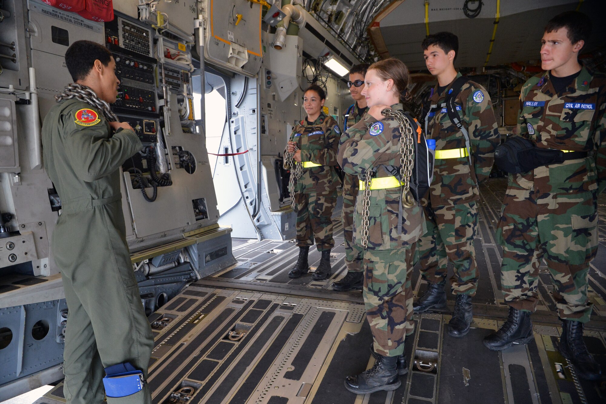 Senior Airman Ryan Kelly, left, 10th Airlift Squadron loadmaster, teaches a group of Civil Air Patrol members how chains are used on a C-17 Globemaster III Aug. 13, 2014, at Joint Base Lewis-McChord, Wash. The Civil Air Patrol members learned about various parts of the aircraft during their tour for their summer encampment. (U.S. Air Force photo/Airman 1st Class Keoni Chavarria)