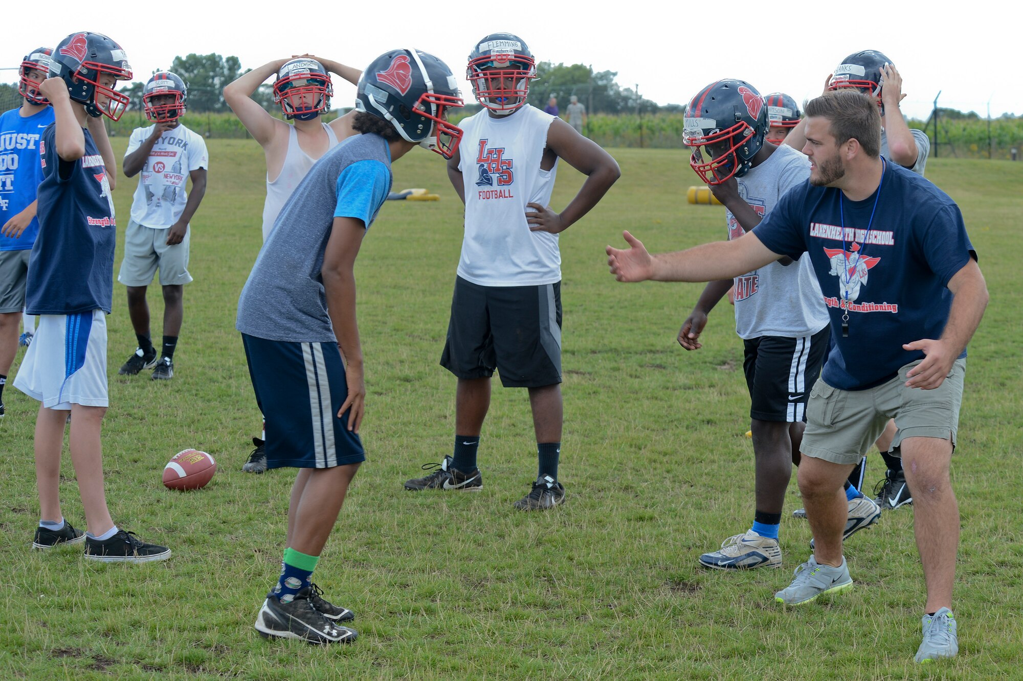 Steve Noble, Lakenheath High School football team defensive coach, explains proper techniques to players during practice at Royal Air Force Lakenheath, England, Aug. 13, 2014. With the 2014-2015 football season underway, the Lakenheath Lancers look to make steps in the right direction for the program. Noble stated, “I have some great young men who have put in hard work throughout the summer workouts, and I can tell they’re hungry.” (U.S. Air Force photo by Airman 1st Class Trevor T. McBride)