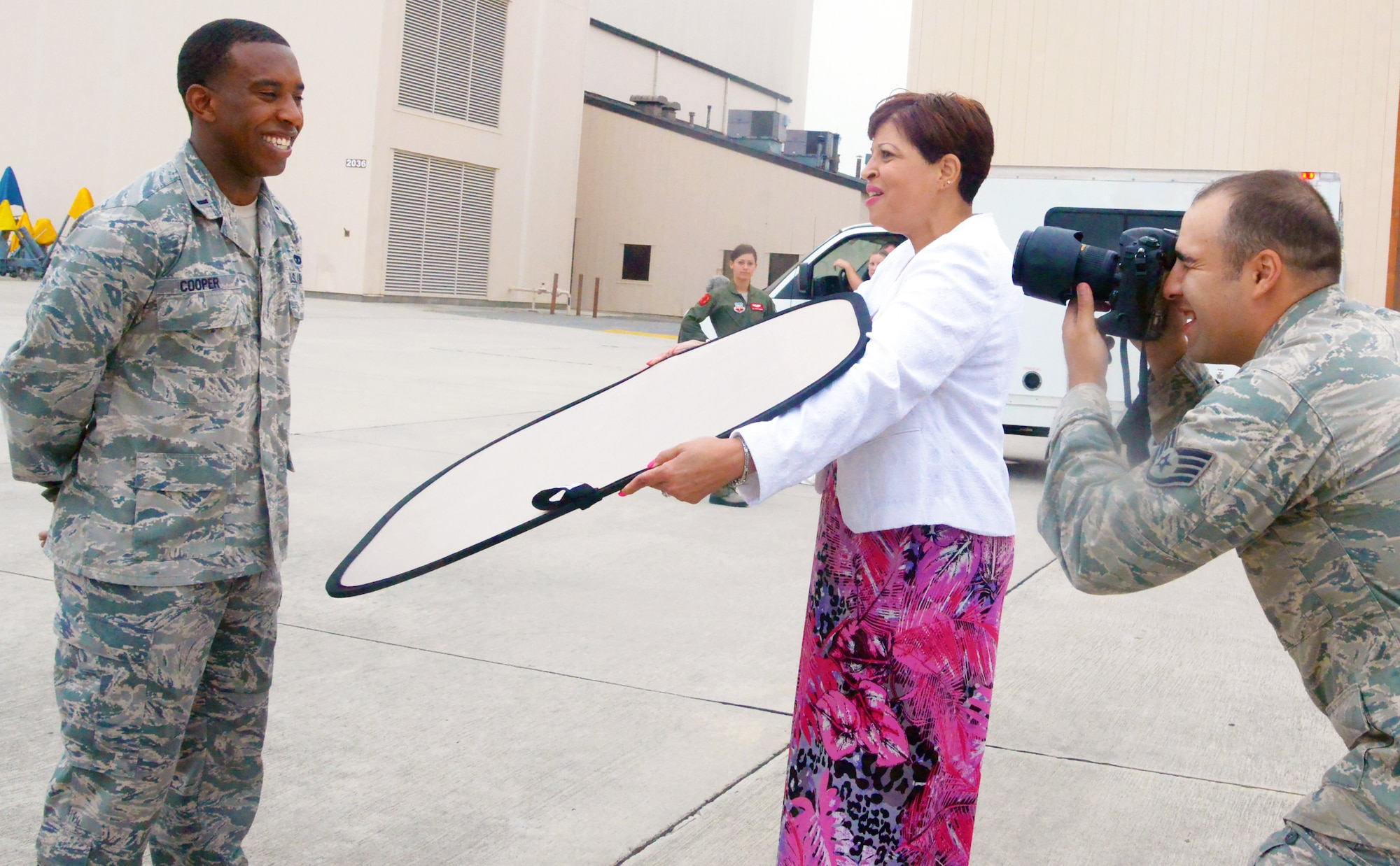1st. Lt. Cameron Cooper, 461st Aircraft Maintenance Squadron assistant aircraft maintenance officer, laughs while posing for an upcoming “Airman Magazine” feature,  August 11, 2014 on the J-STARS flight line. Behind the camera is Staff Sgt. David Salanitri, “Airman Magazine” writer. Assisting is Faye Banks-Anderson, Robins Public Affairs deputy director. (U.S. Air Force photo by Ray Crayton) 