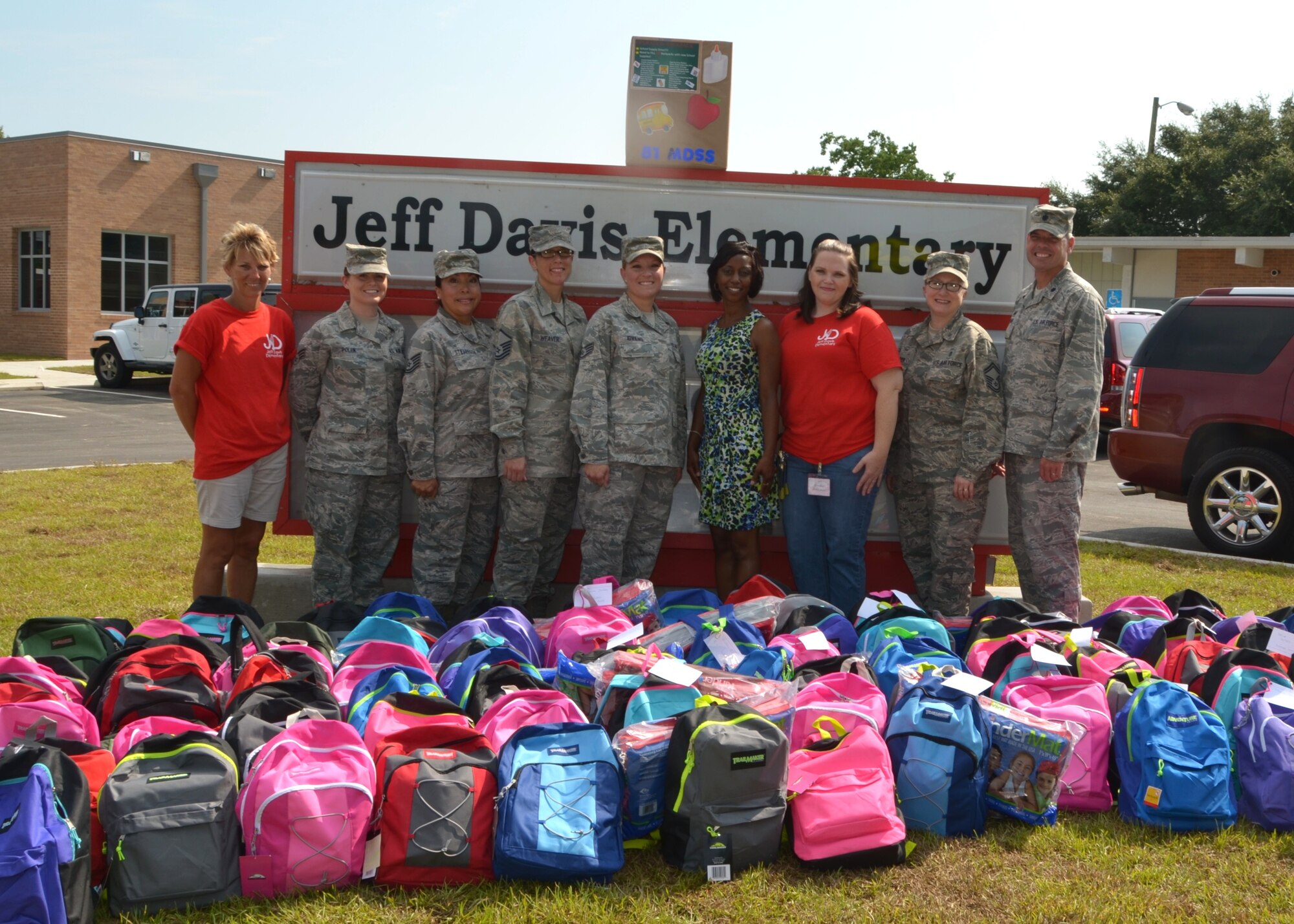 Representatives from Keesler’s 81st Medical Support Squadron join Jeff Davis Elementary School principal Dr. Melanie Nelson, fourth from right, and PTO president Debra Hache, third from right, in front of the facility with the 100 backpacks full of supplies donated to the school’s students Aug. 7.   They are, from left:  squadron commander Lt. Col. Ronald Merchant’s wife (who also serves as PTO vice president), Senior Airman Mandy Polen, Tech. Sgt. Soledad Stevenson, Master Sgt. Michelle Weaver, Staff Sgt. Ashley Iovieno, Senior Master Sgt. Margaret Cooper and Colonel Merchant. (U.S. Air Force photo by Steve Pivnick)