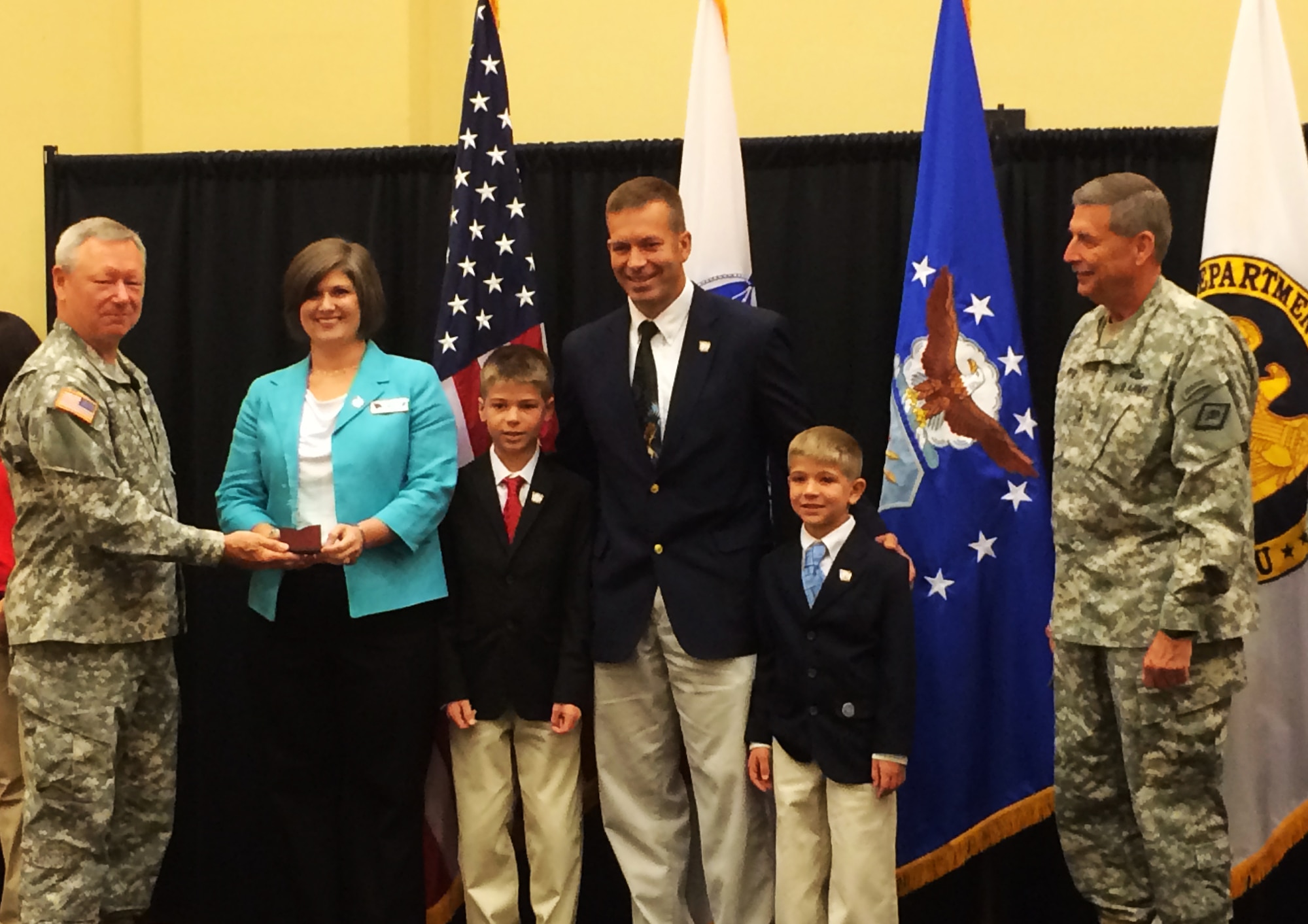 The 188th Wing’s Barr family - Senior Master Sgt. Scott Barr, his wife Cindy and the couples’ children - were awarded National Military Family Association 2014 Family of the Year Award for the Air National Guard. Gen. Frank Grass, chief of the National Guard, left, and Maj. Gen. William Wofford, Arkansas National Guard adjutant general, right, presented the accolade to the Barrs at the national volunteer conference in Norman, Oklahoma, Aug. 13. (Courtesy photo/released)