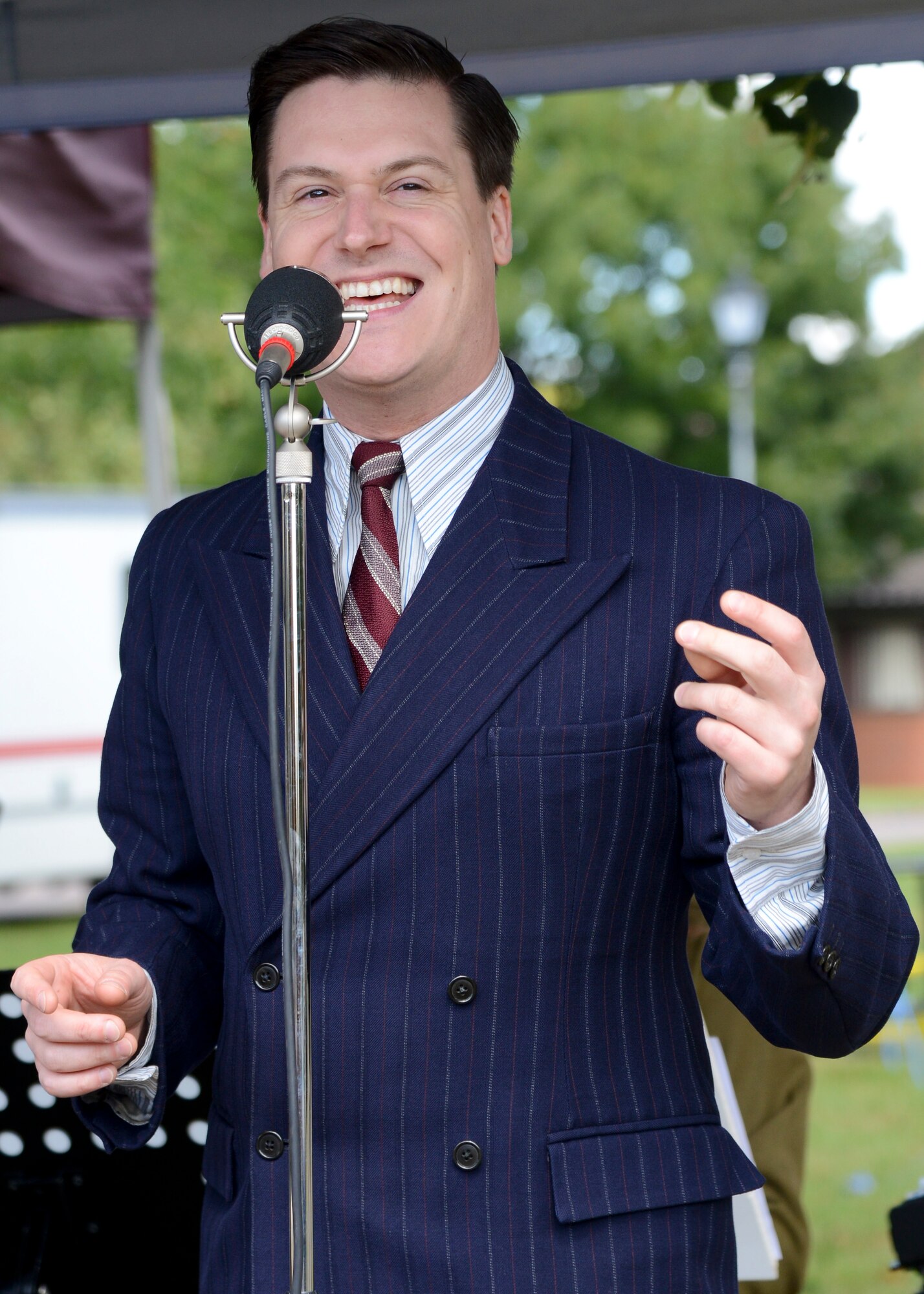 William Kell-Stocker, singer for the band Skyliner, sings during RAF Mildenhall’s 80th anniversary celebration Aug. 15, 2014, on RAF Mildenhall, England. Team Mildenhall members enjoyed multiple performers and a variety of music throughout the event. (U.S. Air Force photo/Airman 1st Class Victoria Taylor/Released)