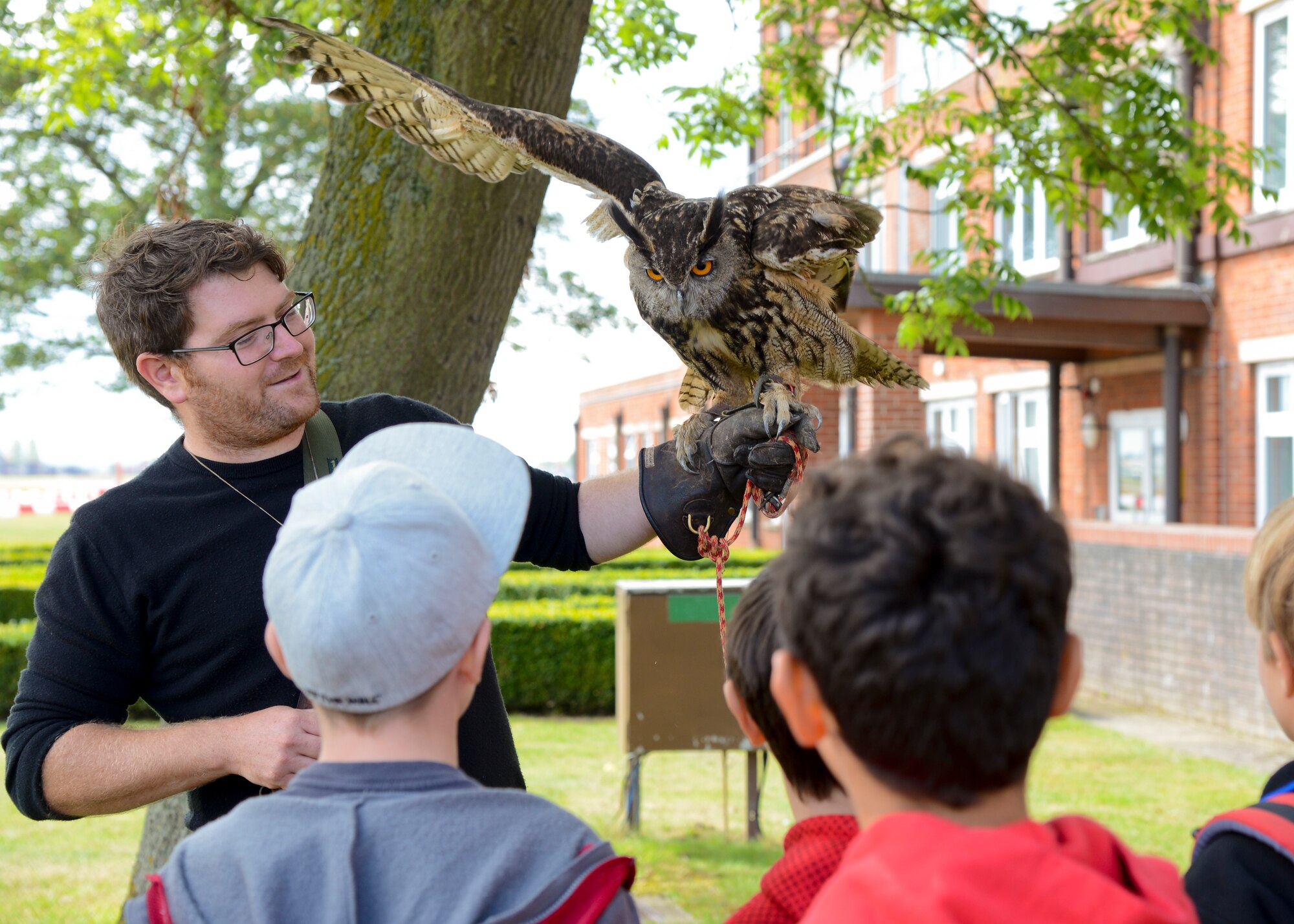 Alan Marenghi, a bird control wildlife biologist, shows Team Mildenhall children an owl during RAF Mildenhall’s 80th anniversary celebration Aug. 15, 2014, on RAF Mildenhall, England. Throughout the event, Team Mildenhall members enjoyed several displays and demonstrations from different units on base. (U.S. Air Force photo/Airman 1st Class Victoria Taylor/Released)