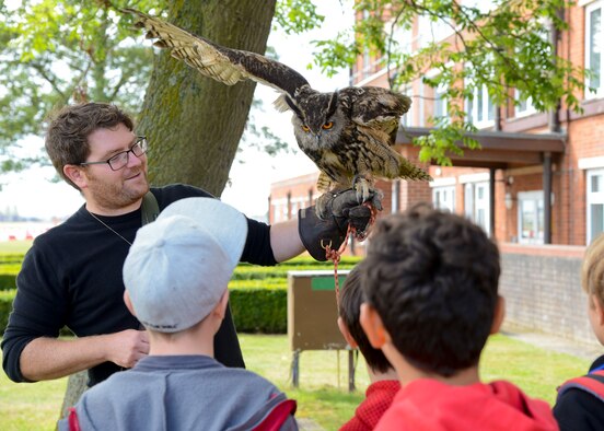 Alan Marenghi, a bird control wildlife biologist, shows Team Mildenhall children an owl during RAF Mildenhall’s 80th anniversary celebration Aug. 15, 2014, on RAF Mildenhall, England. Throughout the event, Team Mildenhall members enjoyed several displays and demonstrations from different units on base. (U.S. Air Force photo/Airman 1st Class Victoria Taylor/Released)
