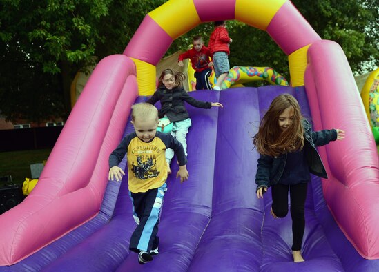 Team Mildenhall children play on a slide during RAF Mildenhall’s 80th anniversary celebration Aug. 15, 2014, on RAF Mildenhall, England. Throughout the day, Team Mildenhall members of all ages enjoyed games, food and demonstrations. (U.S. Air Force photo/Airman 1st Class Jonathan Light/Released)