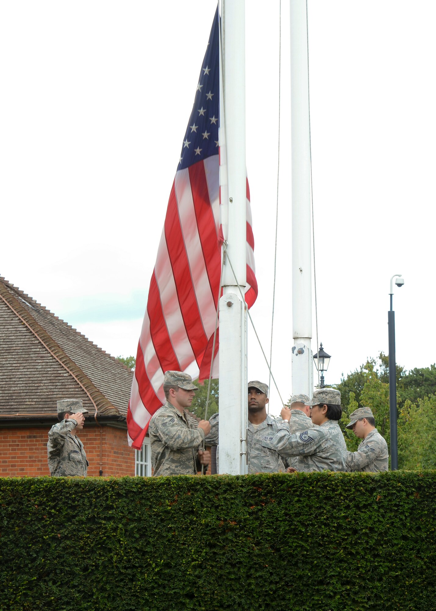 U.S. Air Force Airmen from the RAF Mildenhall Honor Guard lower the U.S. flag during a retreat ceremony concluding RAF Mildenhall’s 80th anniversary celebration Aug. 15, 2014, on RAF Mildenhall, England. The event was designed to communicate and portray what the base was like back in the 1930s, what the squadrons were doing to help the war effort, and how the base has changed throughout time. (U.S. Air Force photo/Airman 1st Class Victoria H. Taylor/Released)