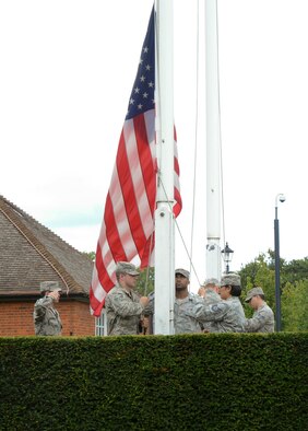 U.S. Air Force Airmen from the RAF Mildenhall Honor Guard lower the U.S. flag during a retreat ceremony concluding RAF Mildenhall’s 80th anniversary celebration Aug. 15, 2014, on RAF Mildenhall, England. The event was designed to communicate and portray what the base was like back in the 1930s, what the squadrons were doing to help the war effort, and how the base has changed throughout time. (U.S. Air Force photo/Airman 1st Class Victoria H. Taylor/Released)