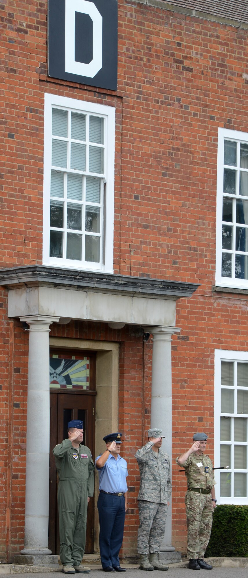 Members of Team Mildenhall and the Royal Air Force participate during a retreat ceremony concluding RAF Mildenhall’s 80th anniversary celebration Aug. 15, 2014, on RAF Mildenhall, England. The base’s fire department, the 352nd Special Operations Group units and the 100th Security Forces Squadron military working dogs were just some of the organizations that provided demonstrations at the event. (U.S. Air Force photo/Airman 1st Class Victoria H. Taylor/Released)