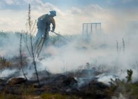 Aaron Radford, a Jackson Guard firefighter, works to put out a smoldering fire after a recent exercise at Duke Field Fla.  The members of Jackson Guard’s wildland fire center are responsible for controlling and maintaining Eglin’s natural resources and operations areas through controlled burning of the it’s forests.  (U.S. Air Force photo/Tech. Sgt. Jasmin Taylor)