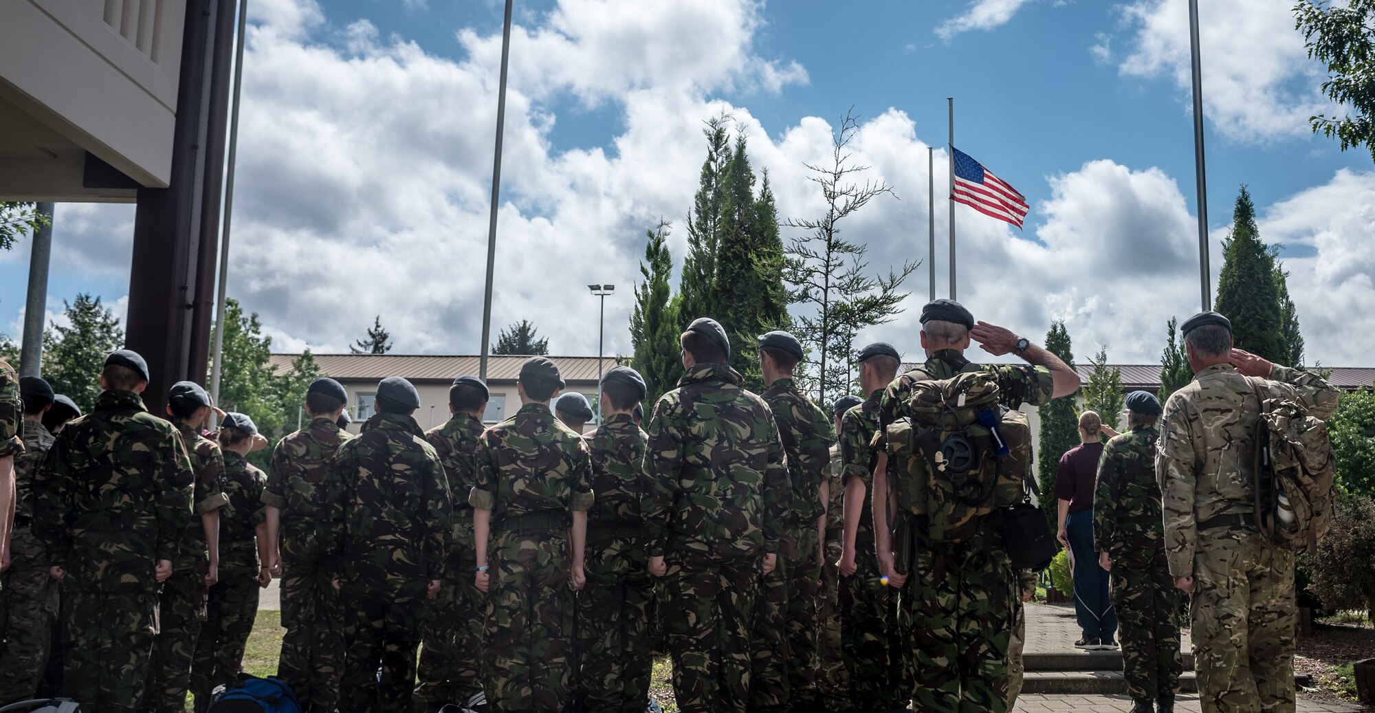 British Air Training Corps cadets and their NCOs pay respect to the American flag during the playing of retreat, on Vogelweh Military Complex, Germany, Aug. 14, 2014. The cadets from England, Whales and Northern Ireland took part in the event that immersed them into the life of a U.S. Air Force NCO attending the Kisling NCOA. (U.S. Air Force photo/Airman 1st Class Jordan Castelan)