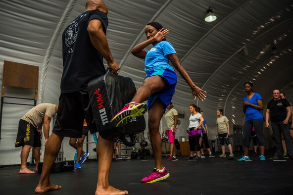 U.S. Air Force Staff Sgt. Myosha Robinson, 386th Air Expeditionary Wing finance customer service technician, practices kicking Staff Sgt. Cameron Cochran, 387th Expeditionary Security Forces Squadron assistant flight chief, during a self-defense class July 26, 2014, at an undisclosed location in Southwest Asia. The class was designed to better prepare Airmen if they are ever attacked. (U.S. Air Force photo by Staff Sgt. Jeremy Bowcock)
