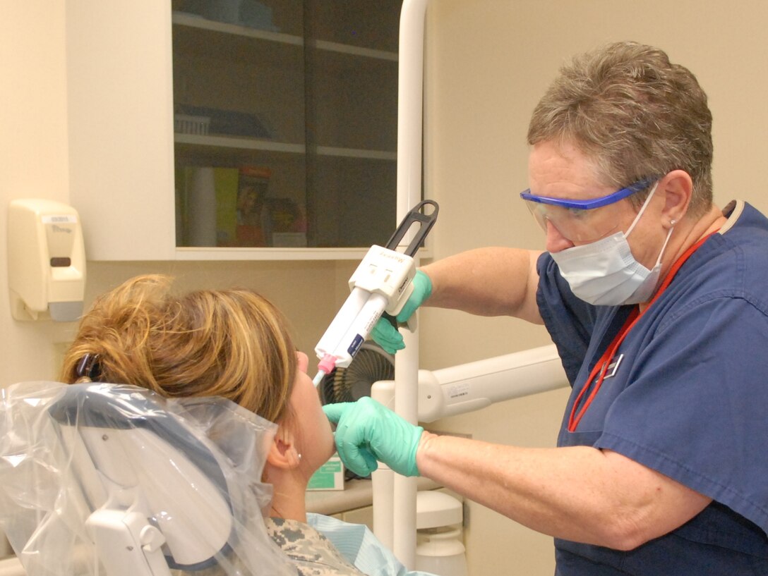 Debra Fitzpatrick, 78th Dental Squadron lead dental assistant, takes dental impressions from Wilber, during an exam August 7, 2014. The dental technician will create a dental splint to relieve the patient’s pain.. (US. Air Force photo by Misuzu Allen)