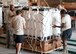 Service member completed a pallet of food and water to prepare it for loading onto aircraft at Al Udeid Air Base, Qatar, Aug. 13, 2014. Volunteers from across the base came out to help build pallets of humanitarian aid, they are completing on average over one hundred pallets a day. The pallets are being airdropped to displaced citizens in the vicinity of Sinjar, Iraq. (U.S. Air Force photo by Senior Airman Colin Cates) 