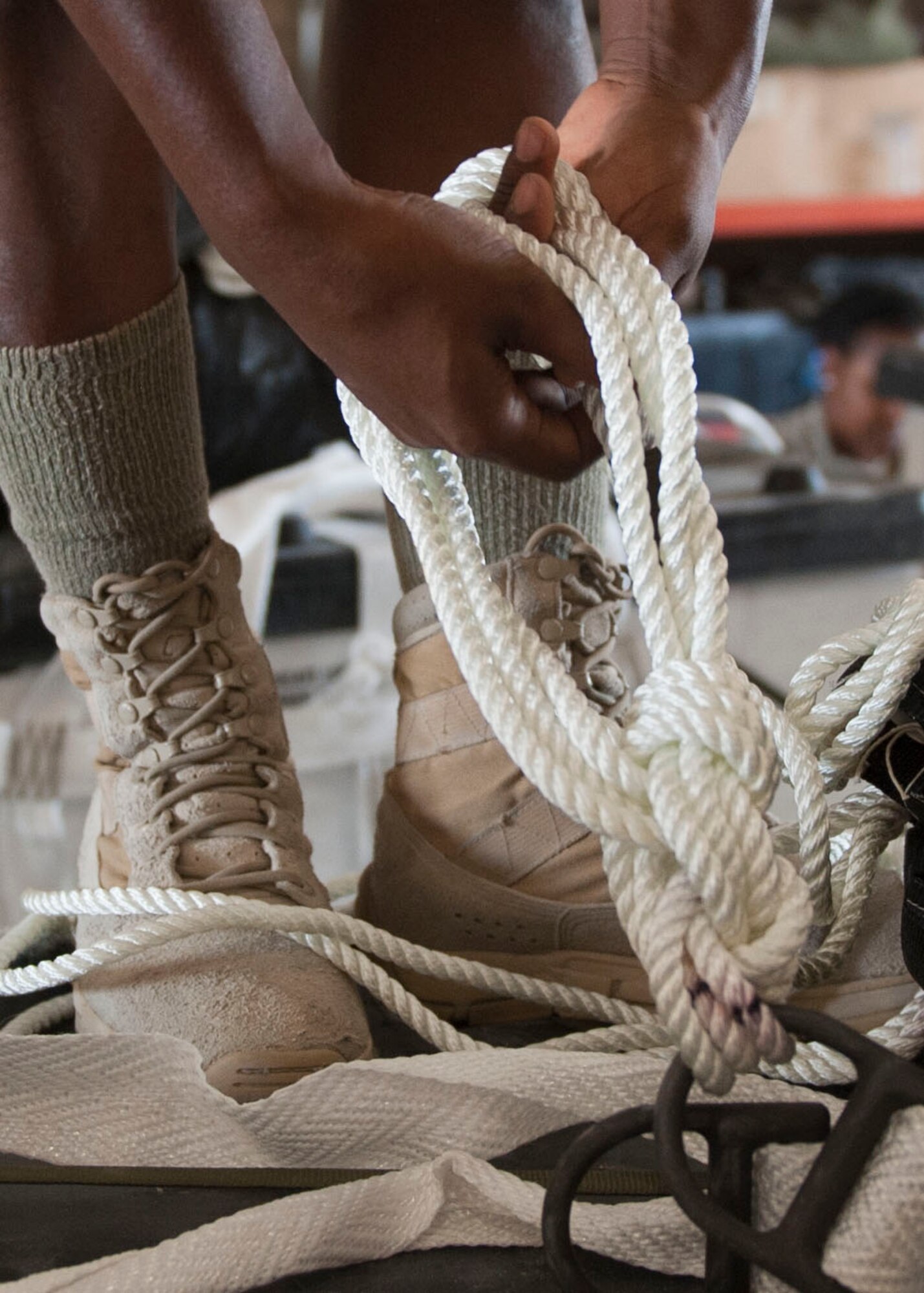 U.S. Army SPC Virgie Merzier parachutte rigger ties a rope on a pallett at Al Udeid Air Base, Qatar, Aug. 13, 2014. Volunteers from across the base came out to help build pallets of humanitarian aid. Merzier  is deployed from the 11th Quartermaster Company, Fort Bragg North Carolina and her hometown is P-au-P, Haiti. (U.S. Air Force photo by Senior Airman Colin Cates)