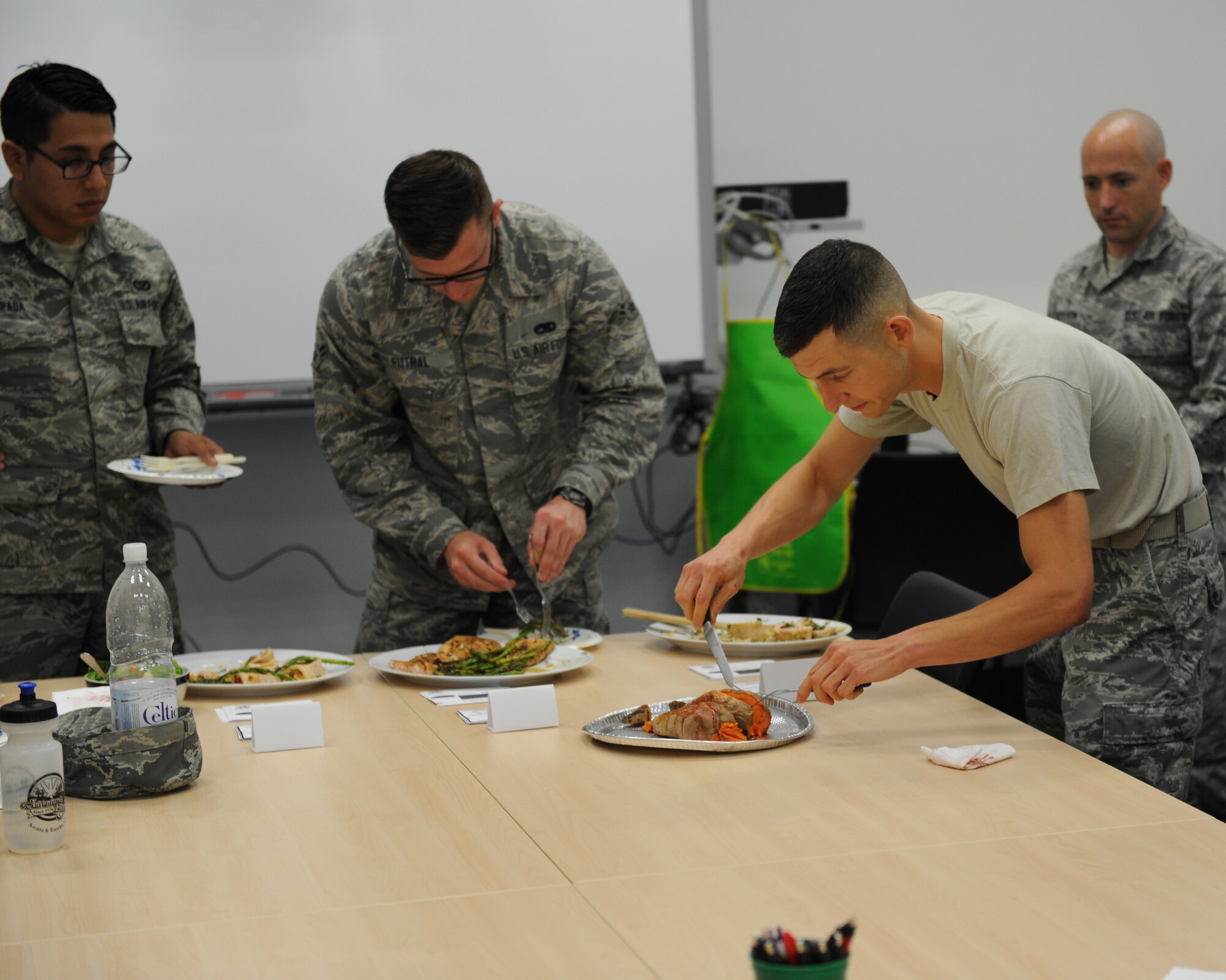 U.S. Air Force Tech. Sgt. David Levine, 52nd Equipment Maintenance Squadron NCO in charge of munitions stock control, front, finishes prepping sweet potatoes during the Ultimate Chef competition Aug. 13, 2014, at Spangdahlem Air Base, Germany. Levine’s pan-seared salmon, asparagus and sweet potato dish earned him the title of “Ultimate Chef.” (U.S. Air Force photo by Airman 1st Class Dylan Nuckolls/Released)
