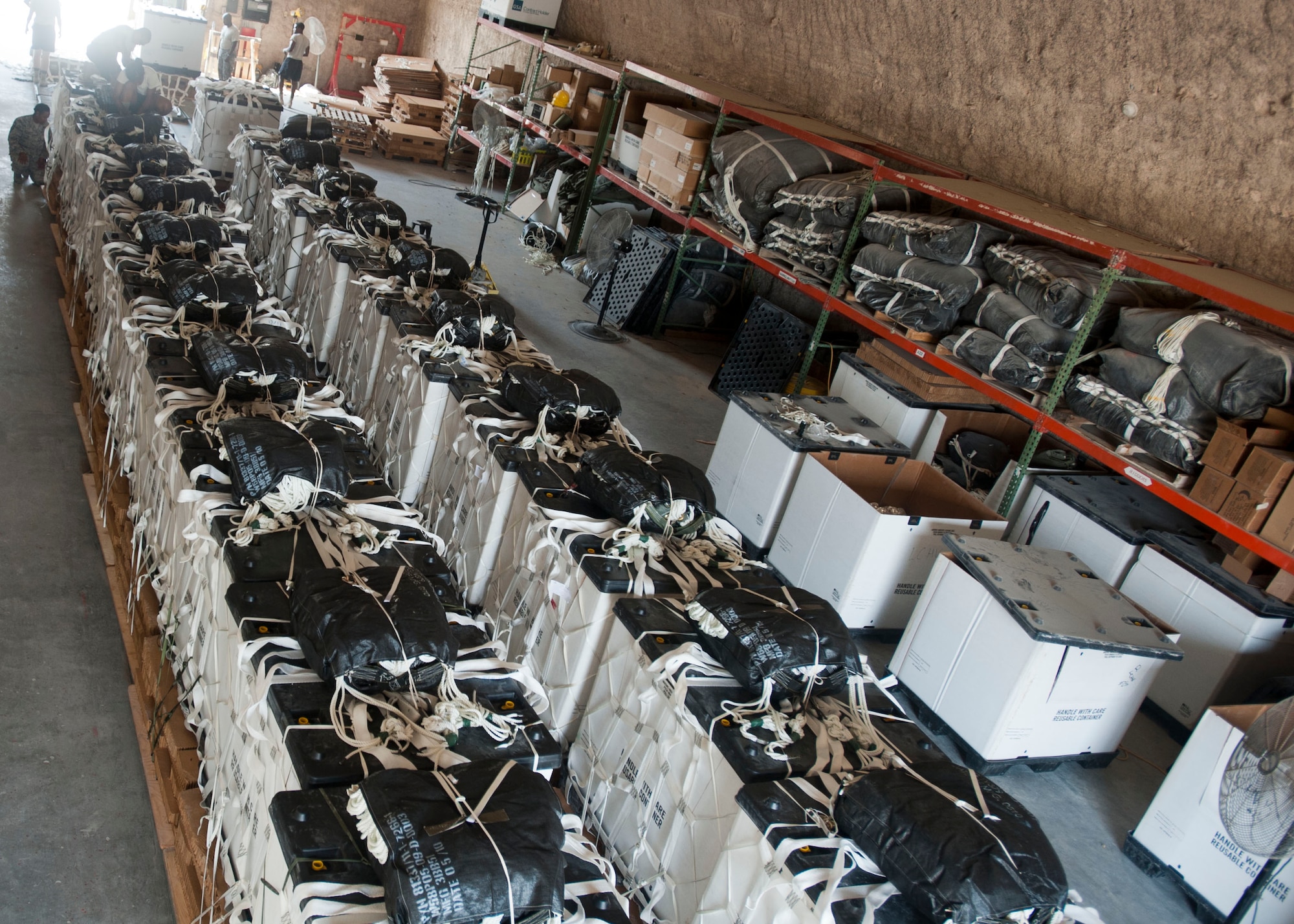 Completed pallets are lined up, to be transported onto an aircraft at Al Udeid Air Base, Qatar, Aug. 13, 2014. Volunteers from across the base came out to help build pallets of humanitarian aid. The pallets are being airdropped to displaced citizens in the vicinity of Sinjar, Iraq. (U.S. Air Force photo by Senior Airman Colin Cates)