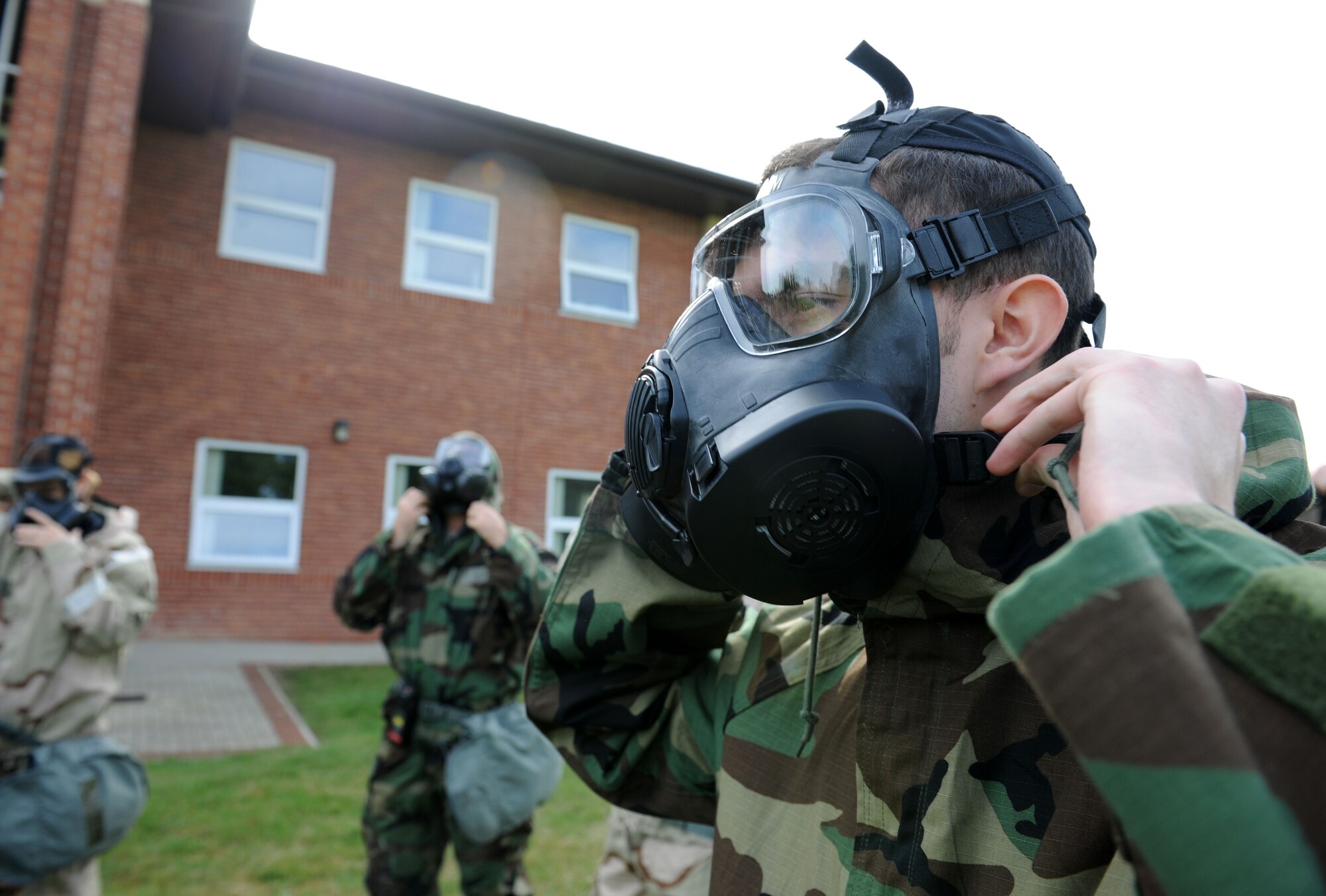 U.S. Air Force Airman 1st Class Eric Yancey, 352nd Special Operations Maintenance Squadron communication and navigation mission systems technician from Lowville, N.Y., dons his gas mask during a chemical, biological, radiological and nuclear training class Aug. 14, 2014, at building 680 on RAF Mildenhall, England. Before the practical application, Airmen learned how to properly don their mission-oriented protective posture suits and inspect their gas masks. (U.S. Air Force photo/Senior Airman Kate Maurer/Released)
