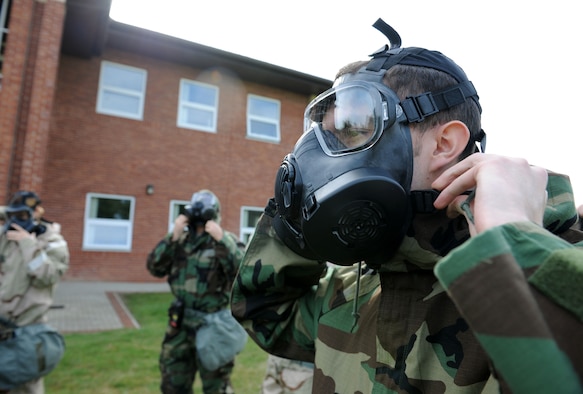 U.S. Air Force Airman 1st Class Eric Yancey, 352nd Special Operations Maintenance Squadron communication and navigation mission systems technician from Lowville, N.Y., dons his gas mask during a chemical, biological, radiological and nuclear training class Aug. 14, 2014, at building 680 on RAF Mildenhall, England. Before the practical application, Airmen learned how to properly don their mission-oriented protective posture suits and inspect their gas masks. (U.S. Air Force photo/Senior Airman Kate Maurer/Released)