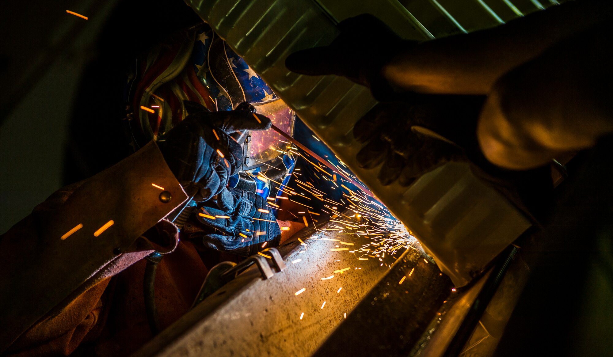 Staff Sgt. Tyrone Sanders, 557th Expeditionary RED HORSE Squadron structures craftsman, welds in place a section of a K-Span building Aug. 4, 2014 at an undisclosed location in Southwest Asia. Airmen from the 557th ERHS came from Al Udeid to build two K-Span buildings to establish more permanent structures than the current tents used as passenger terminals. The unit is comprised of all Air National Guard members deployed from Penn. in support of Operation Enduring Freedom. (U.S. Air Force photo by Staff Sgt. Jeremy Bowcock)