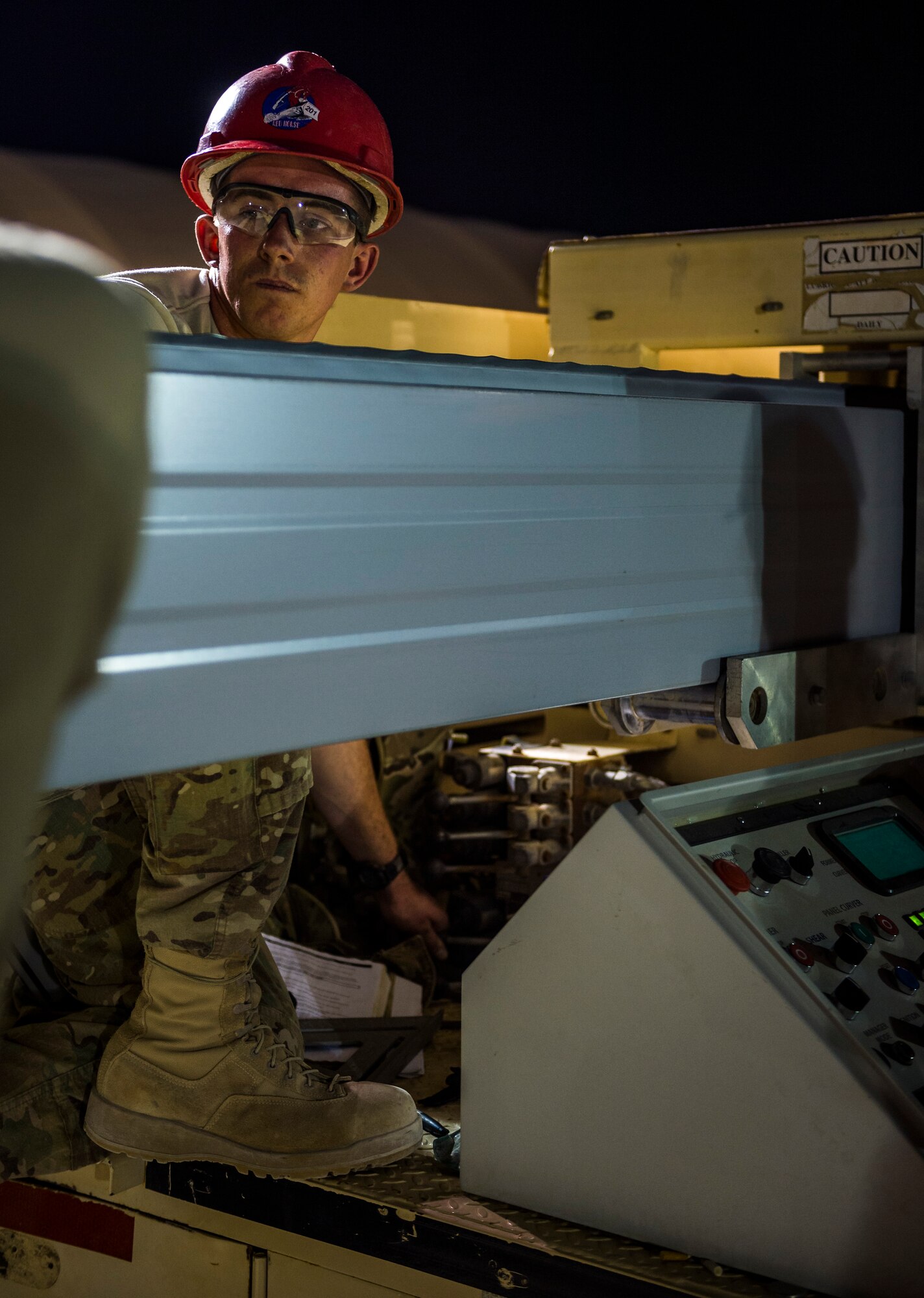 Staff Sgt. James Derbyshire, 557th Expeditionary RED HORSE Squadron structures craftsman, runs an Ultimate Building Machine to shape steel arches for a K-Span building Aug. 3, 2014 at an undisclosed location in Southwest Asia. Airmen from the 557th ERHS came from Al Udeid to build two K-Span buildings to establish more permanent structures than the current tents used as passenger terminals. The unit is comprised of all Air National Guard members deployed from Penn. in support of Operation Enduring Freedom. (U.S. Air Force photo by Staff Sgt. Jeremy Bowcock)