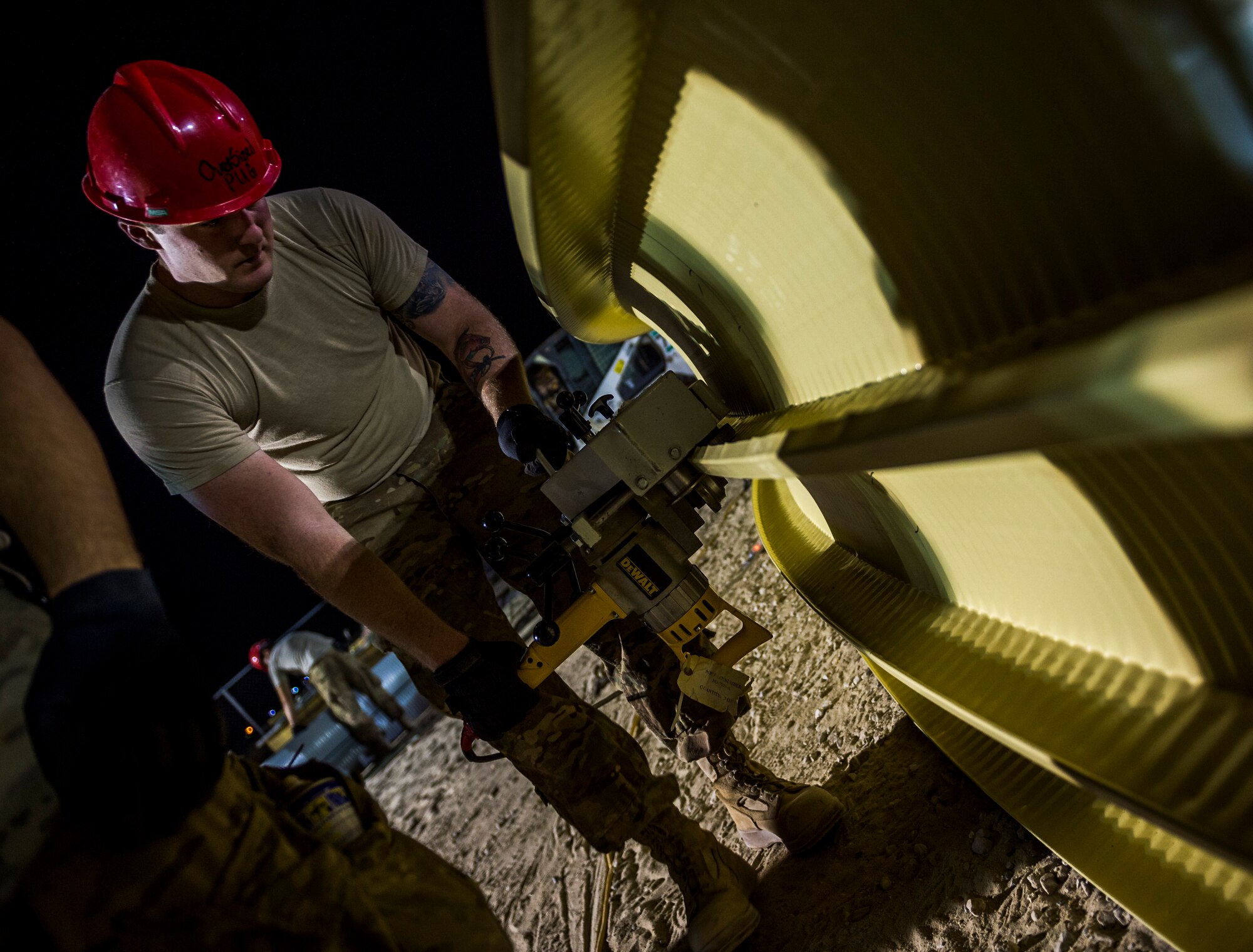 Senior Airman James Driscoll, 557th Expeditionary RED HORSE Squadron pavement and equipment operator, uses a hand seamer to bind two steel arches together Aug. 3, 2014 at an undisclosed location in Southwest Asia. Airmen from the 557th ERHS came from Al Udeid to build two K-Span buildings to establish more permanent structures than the current tents as used passenger terminals. The unit is comprised of all Air National Guard members deployed from Penn. in support of Operation Enduring Freedom. (U.S. Air Force photo by Staff Sgt. Jeremy Bowcock)