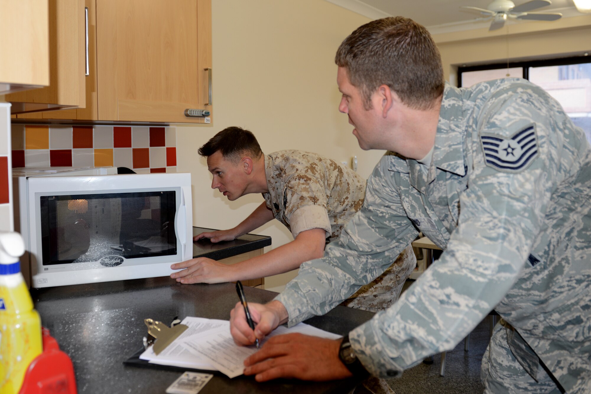 U.S. Marine Corps Gunnery Sgt. Randal Lundquist and U.S. Air Force, Tech. Sgt. Kevin Kind, both Geospatial Intelligence Analysts from the Joint Intelligence Operations Center-Europe Analytic Center (JAC) at RAF Molesworth, United Kingdom, conduct a monthly dormitory inspection, at RAF Alconbury, U.K, August 15, 2014. The 423rd Air Base Group and local mission partner leadership conduct required health, morale and welfare dormitory inspections to ensure service members are upholding military standards both on and off duty. (U.S. Air Force photo by Tech. Sgt. Chrissy Best) 