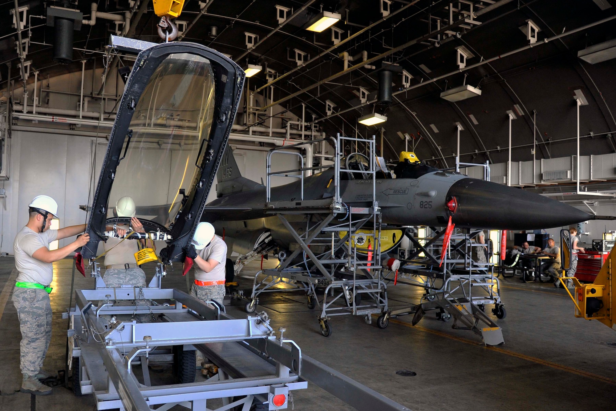 U.S. Air Force Senior Airmen Luke Duncan and Jeffrey Bowen, 35th Maintenance Squadron aircrew egress systems journeymen and Airman 1st Class Peter Curry, aircrew egress systems apprentice, prepare an F-16 Fighting Falcon’s canopy to be installed on the aircraft’s fuselage at Misawa Air Base, Japan, Aug. 11, 2014. Attaching the canopy marks the last step of the life support and escape system maintenance process. After the seat is inserted and cockpit encapsulated, the jet is ready to be flown. (U.S. Air Force photo/Airman 1st Class Patrick S. Ciccarone)