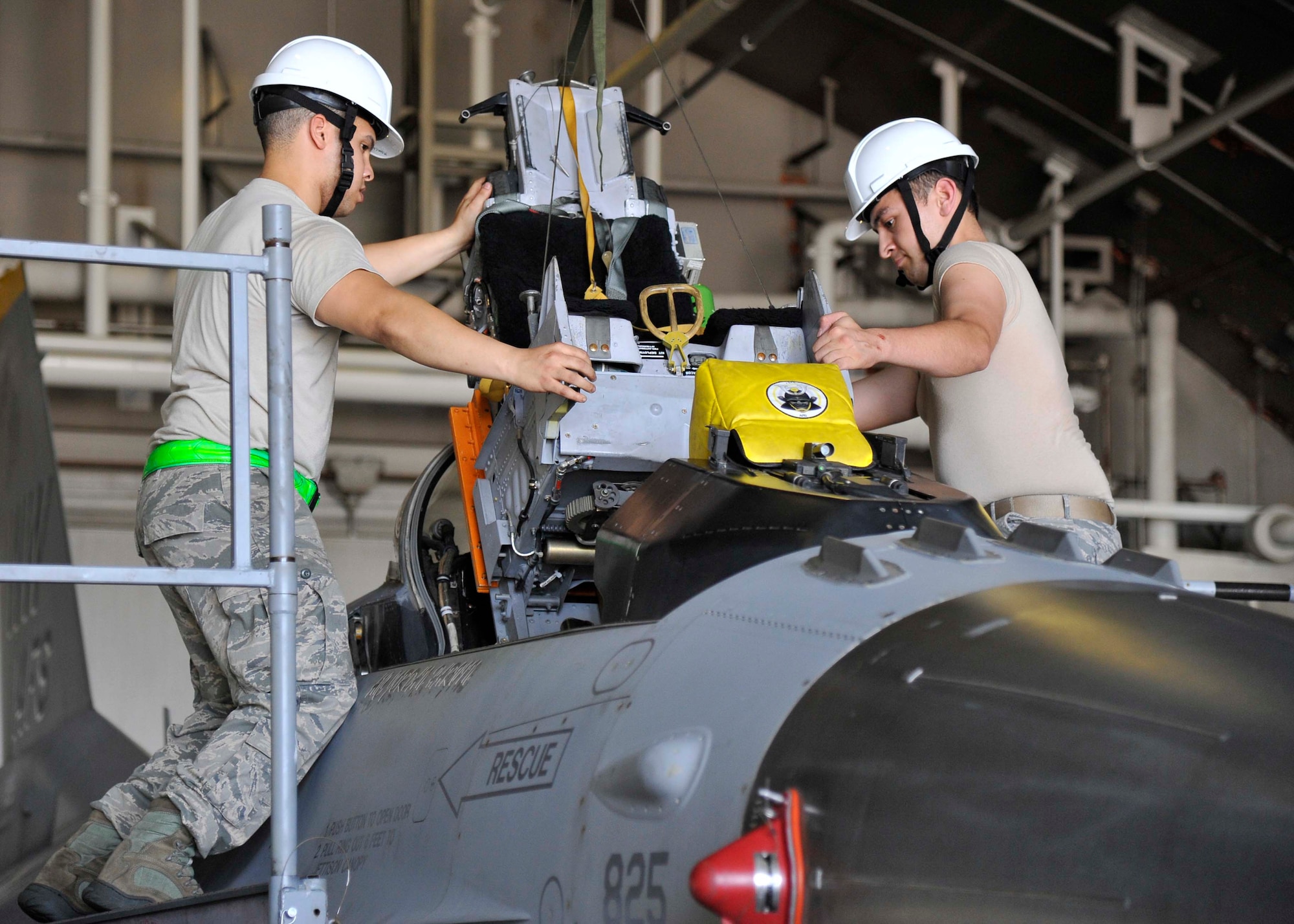 U.S. Air Force Senior Airmen Luke Duncan and Jeffrey Bowen, 35th Maintenance Squadron aircrew egress systems journeymen, install an F-16 Fighting Falcon’s seat into its cockpit at Misawa Air Base, Japan, Aug. 11, 2014. After ensuring the cockpit’s seating panels are unobstructed, the egress team uses a crane to precisely lower the seat into the aircraft’s framework and then lock it into place. (U.S. Air Force photo/Airman 1st Class Patrick S. Ciccarone)