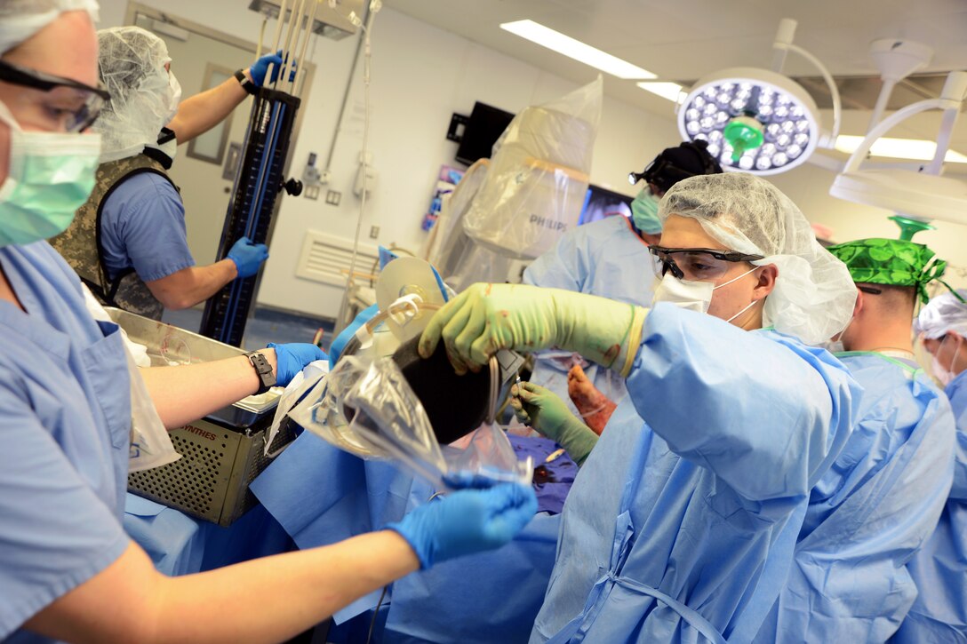 U.S. Air Force Captain Amanda Eagan, right, opens a blood bag for U.S. Air Force Airman 1st Class German Martinez as he prepares to hand the blood to the surgeons to use on a patient in the Craig Joint Theater Hospital on Bagram Airfield, Afghanistan, Aug. 5, 2014. Eagan, an operating room nurse, and Martinez, an orthopedic scrub technician, are assigned to the 455th Expeditionary Medical Group.