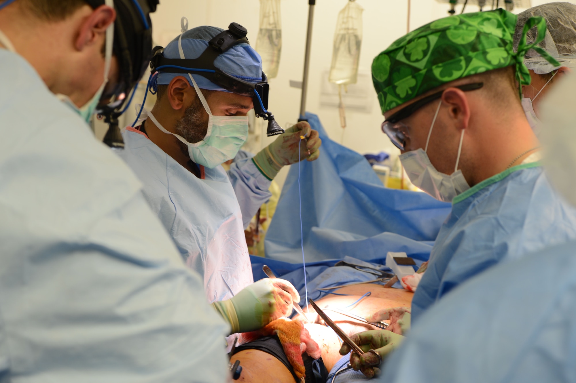 U.S. military doctors work together to close a wound of a patient at the Craig Joint Theater Hospital, Bagram Airfield, Afghanistan Aug. 5, 2014. The team of doctors administered emergency and vital care to the victims of a mass casualty incident. (U.S. Air Force photo by Master Sgt. Cohen A. Young/Released)