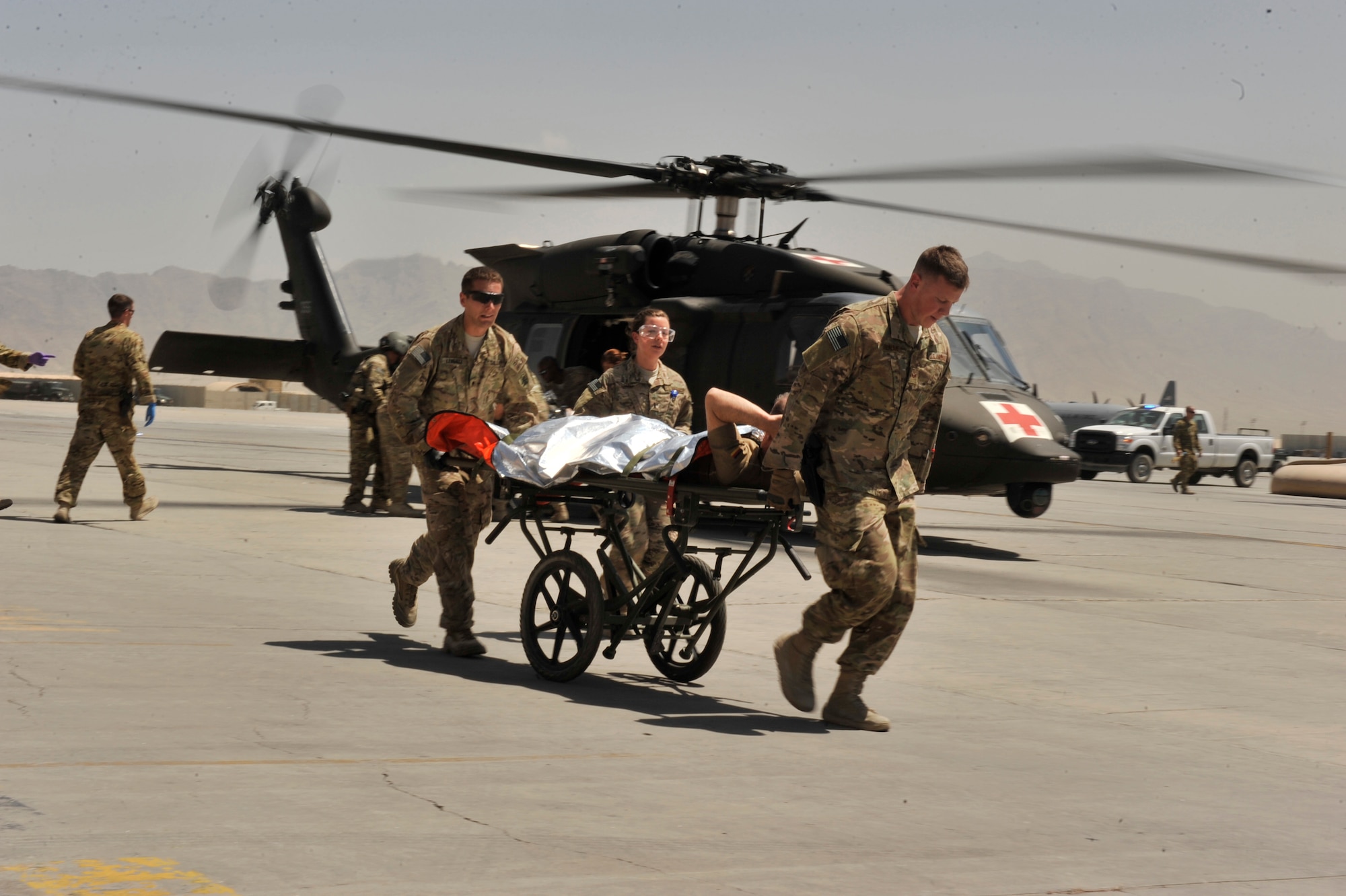U.S. Army Spec. Tyler Lenertz (left), U.S. Air Force 1st Lt. Helene Gold (center), and Senior Airman Lucas Reaume (right) rush a patient into the Craig Joint Theater Hospital during a mass casualty response at Bagram Airfield, Afghanistan on Aug. 5, 2014. Lenertz is deployed from the 814th Area Support Medical Co., Bismarck, N.D., while Gold and Reaume are deployed from Joint Base San Antonio, Texas. (U.S. Air Force photo by Maj. Brandon Lingle/Released) 