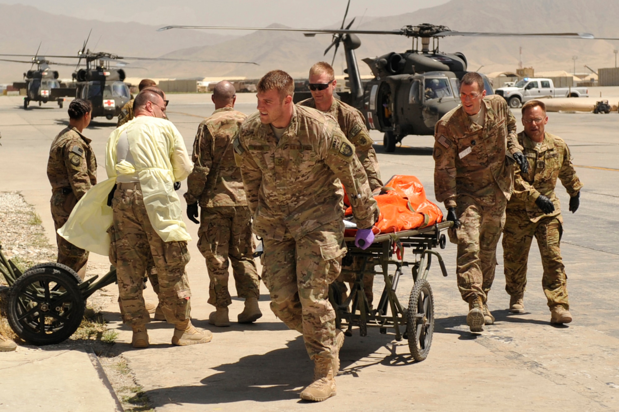 U.S. Air Force Senior Airman Bryant Wilson, U.S. Army Sgt. Ted Werre, and U.S. Air Force Maj. William Leasure rush a patient into the Craig Joint Theater Hospital during a mass casualty response at Bagram Airfield, Afghanistan on Aug. 5, 2014. Wilson is deployed from Joint Base San Antonio, Texas. Leasure is deployed from Offutt Air Force Base, Neb., and Were is deployed from the 814th Area Support Medical Co., Bismarck, N.D. (U.S. Air Force photo by Maj. Brandon Lingle/Released)