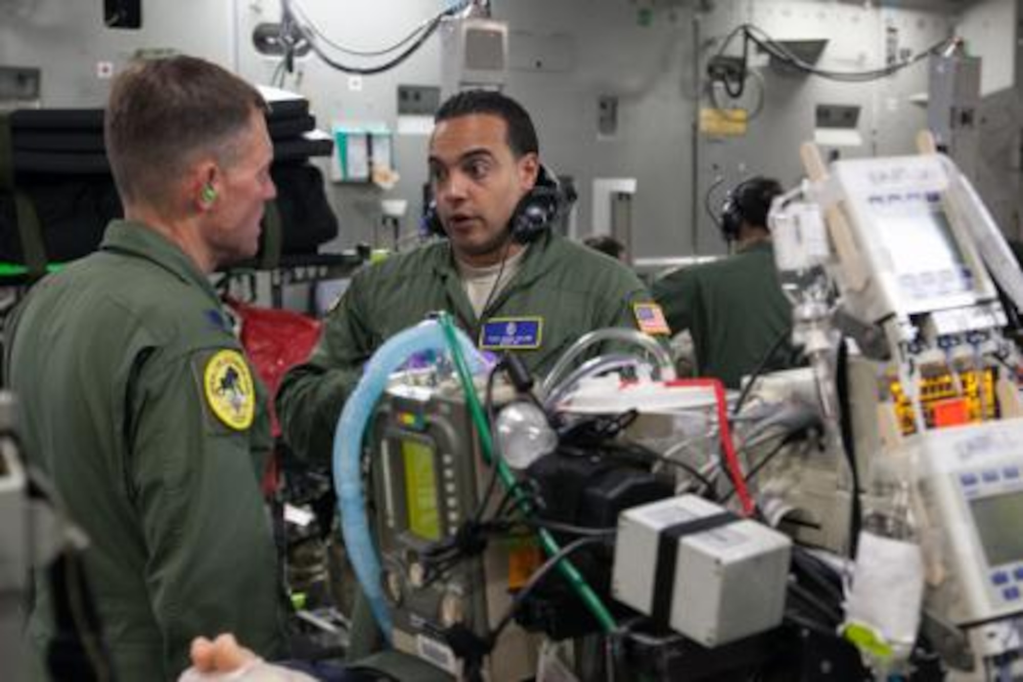 Lt. Col. Patrick Johannes, left, and Tech. Sgt. Eddie Colon, both assigned to the 10th Expeditionary Aeromedical Evacuation Flight, discuss a patient's care during a flight from Ramstein Air Base, Germany, July 4, 2014. Johaness and Colon are members of a Critical Care Air Transport Team. (U.S. Air National Guard photo by Staff Sgt. Allan Eason/Released)



