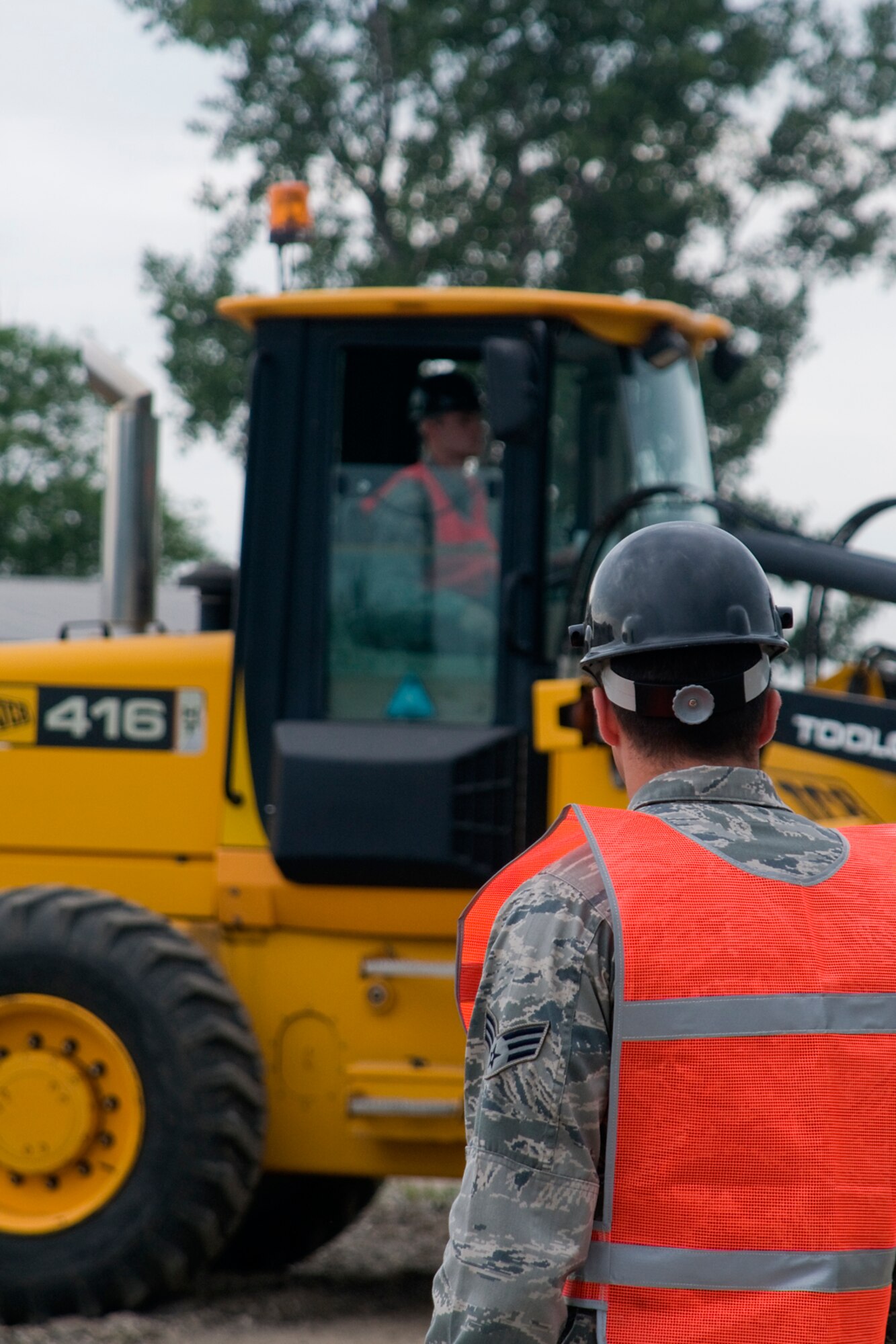 Senior Airman Blake Vohs helps guide Senior Airman Thomas White as he operates a frontend loader during construction of an explosive ordnance disposal training area at Grissom Air Reserve Base, Ind., Aug. 10, 2014. Both Airmen are pavements and construction apprentices with the 434th Civil Engineer Squadron. (U.S. Air Force photo/Staff Sgt. Andrew McLaughlin)

