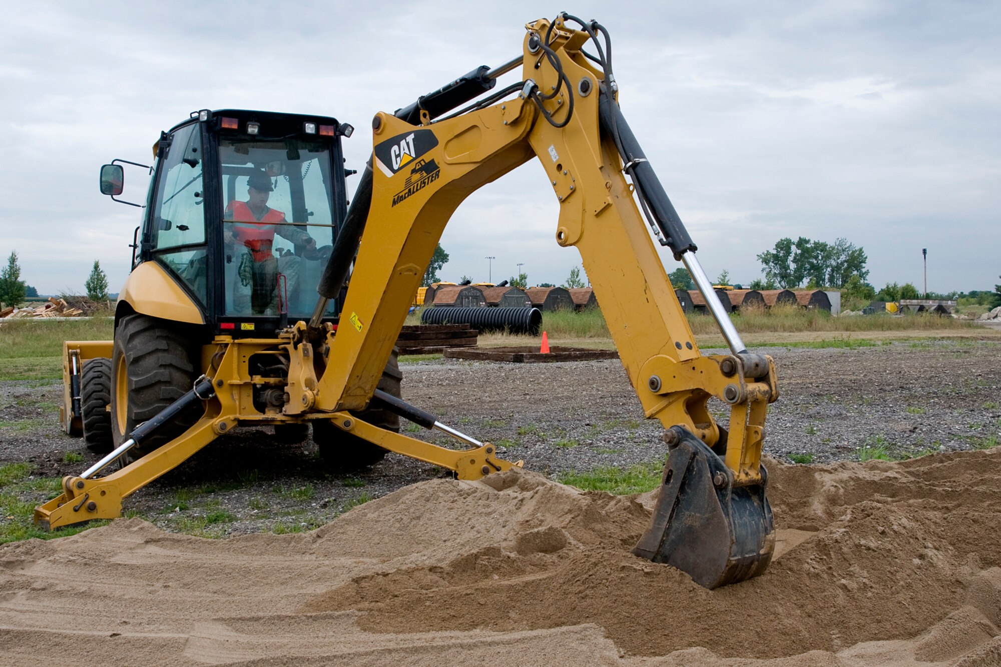 Senior Airman Steven Litviak, 434th Civil Engineer Squadron pavements and construction apprentice, uses a backhoe to fill a sand pit as part of an explosive ordnance disposal training area at Grissom Air Reserve Base, Ind., Aug. 10, 2014. The sand pit will be used for landmine detection and disposal training. (U.S. Air Force photo/Staff Sgt. Andrew McLaughlin)
