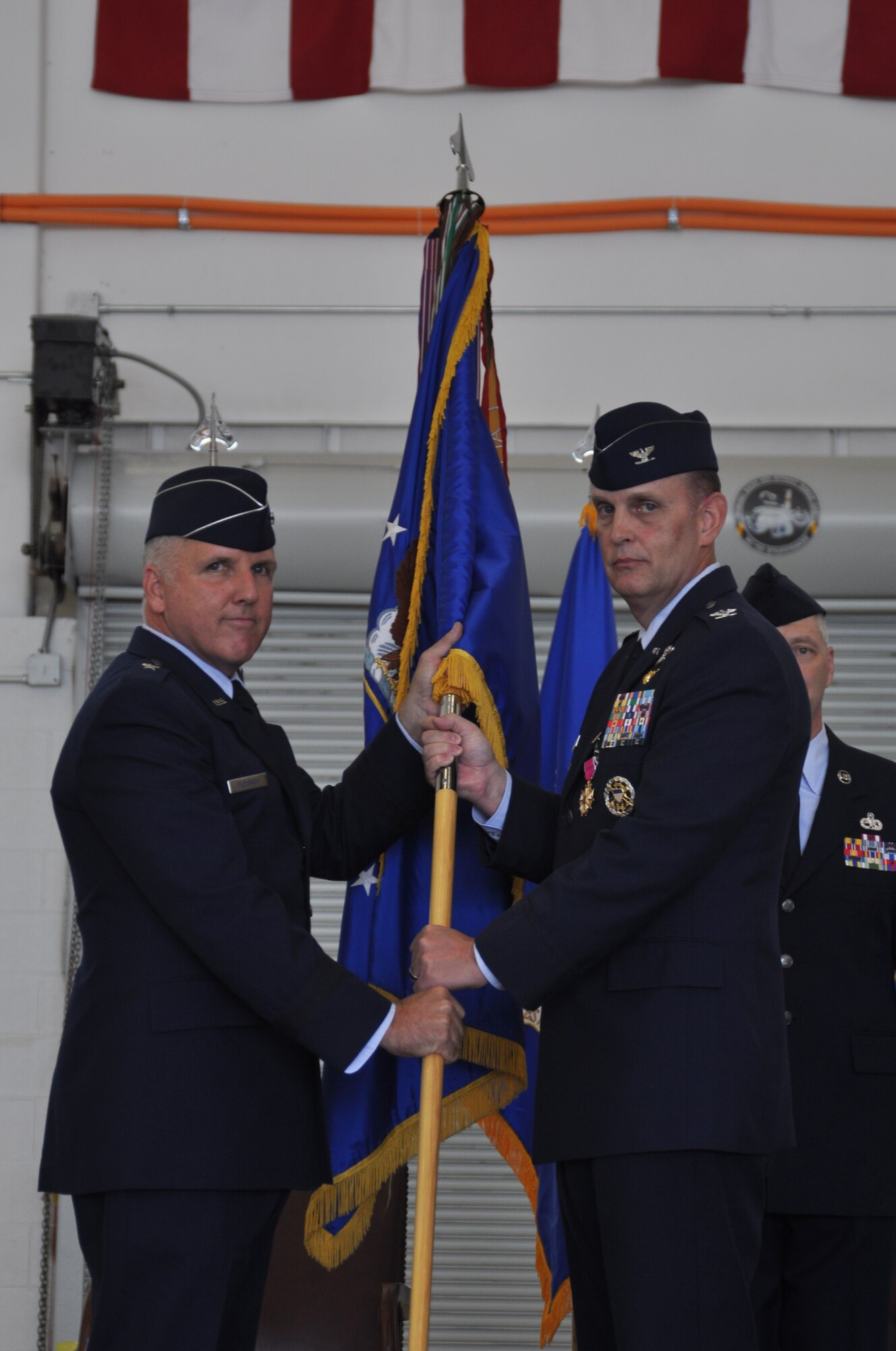 Brigadier Gen. John C. Flournoy, 4th Air Force commander and presiding officer, accepts the guide-on from Col. William H. Mason, 459th Air Refueling Wing commander, who is relinquishing command at the change of command ceremony held in Hangar 10 on August 16, 2014. (U.S. Air Force photo/ Staff Sgt. Amber J. Russell)