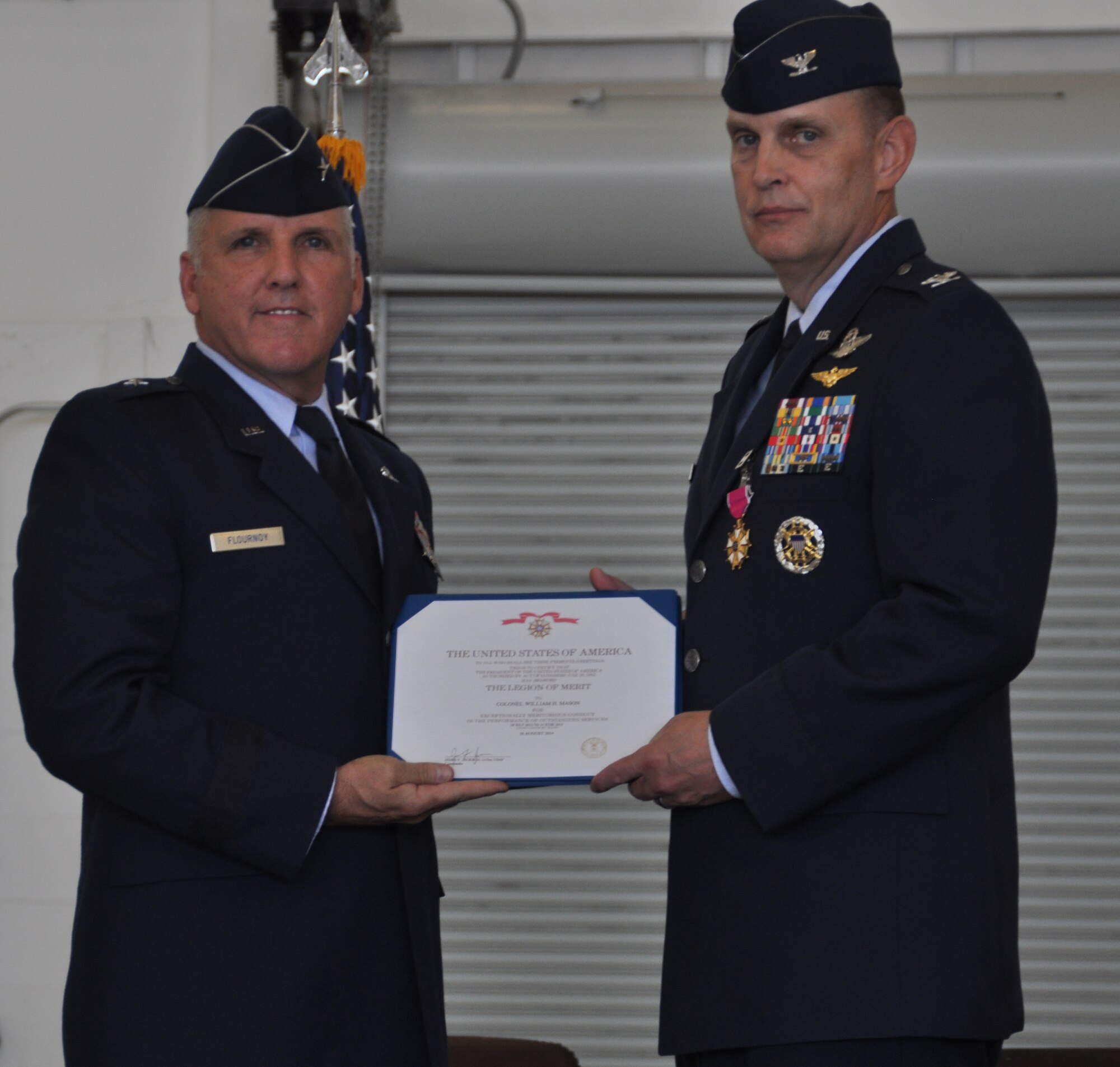 Brigadier Gen. John C. Flournoy, 4th Air Force commander and presiding officer at the change of command ceremony held in Hangar 10, presents Col. William H. Mason, former 459th Air Refueling Wing commander, with the Legion of Merit on August 16, 2014. (U.S. Air Force photo/ Staff Sgt. Amber J. Russell)  
