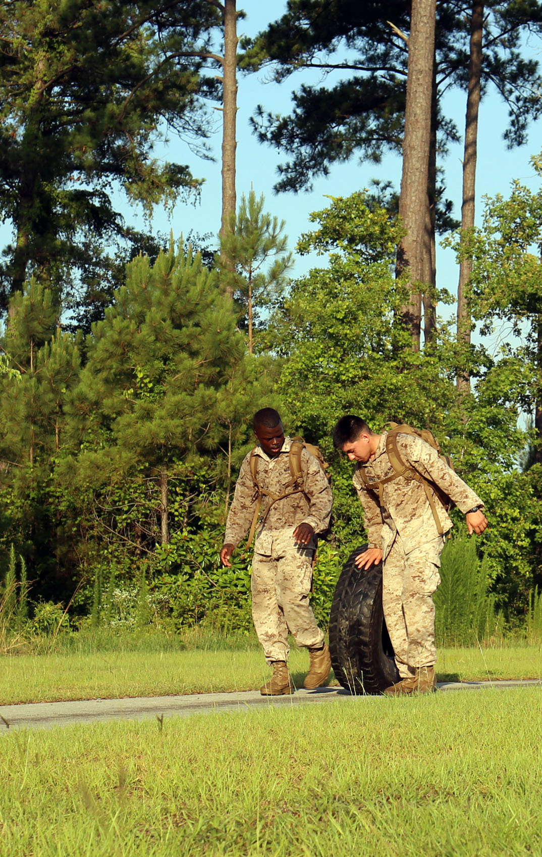 Marines from 2nd Battalion, 2nd Marine Regiment, 2nd Marine Division roll a tire during the Battalion's Endurance Event June 20 at Camp Lejeune. The Marines were split into teams and competed for the fastest times against other teams in the Batttalion. (U.S. Marine Corps photo by Lance Cpl. Ryan Young/released)